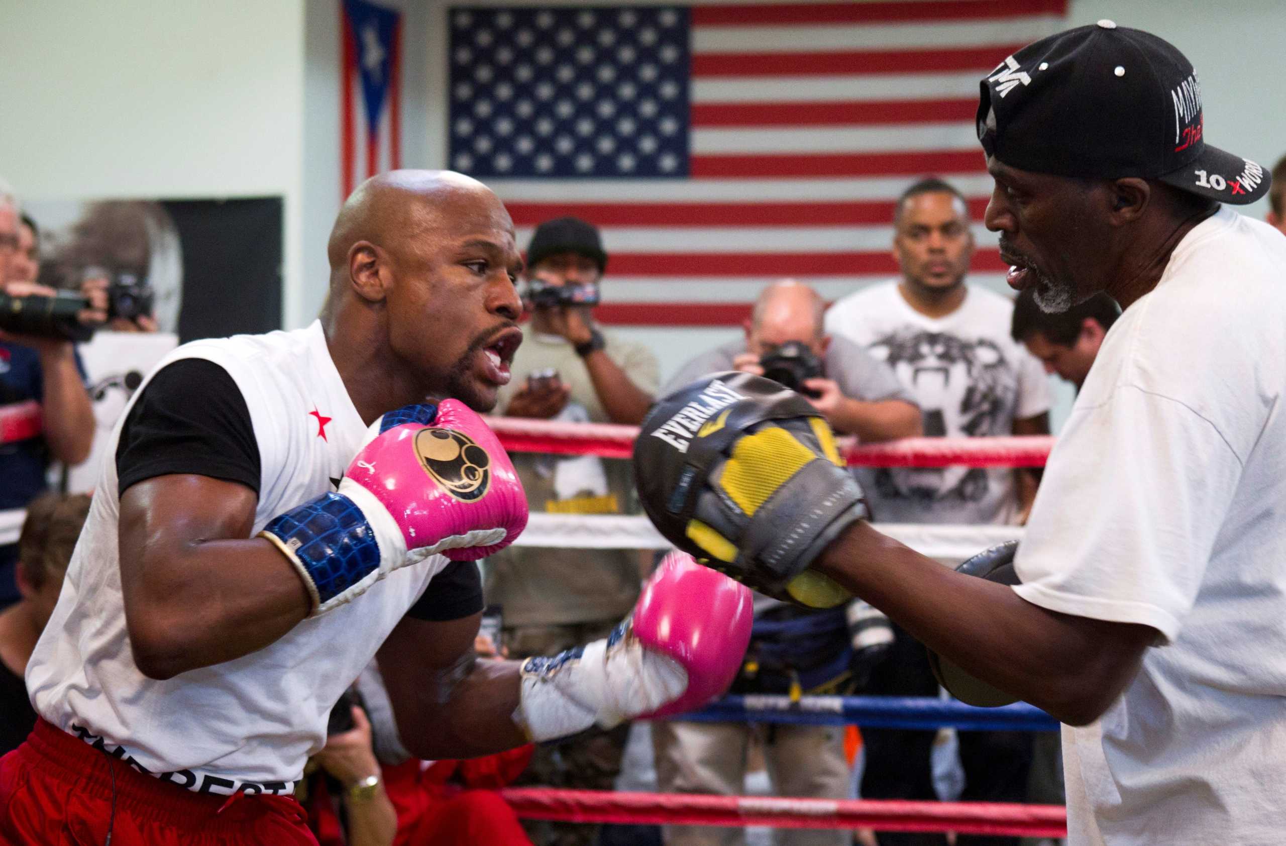 FILE PHOTO: World Boxing Council (WBC) welterweight champion Floyd Mayweather Jr. (L) of the U.S. works on his timing with his uncle and trainer Roger Mayweather at the Mayweather Boxing Club in Las Vegas, Nevada April 22, 2014. REUTERS