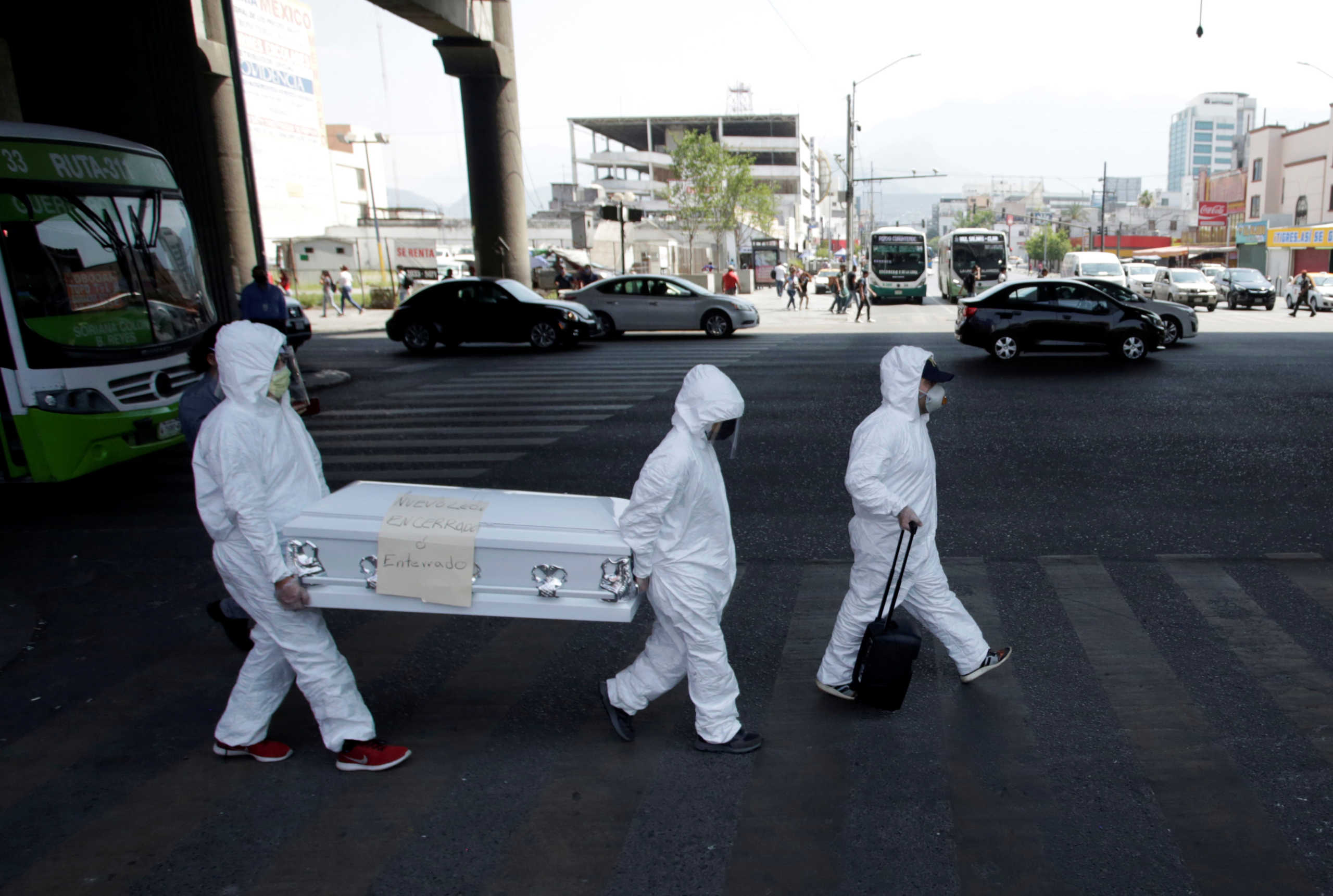 Activists wearing protective suits carry a coffin with a banner attached that says "Nuevo Leon locked up or buried" as part of an awareness campaign, amid the spread of the coronavirus disease (COVID-19), in Monterrey, Mexico April 20, 2020. REUTERS