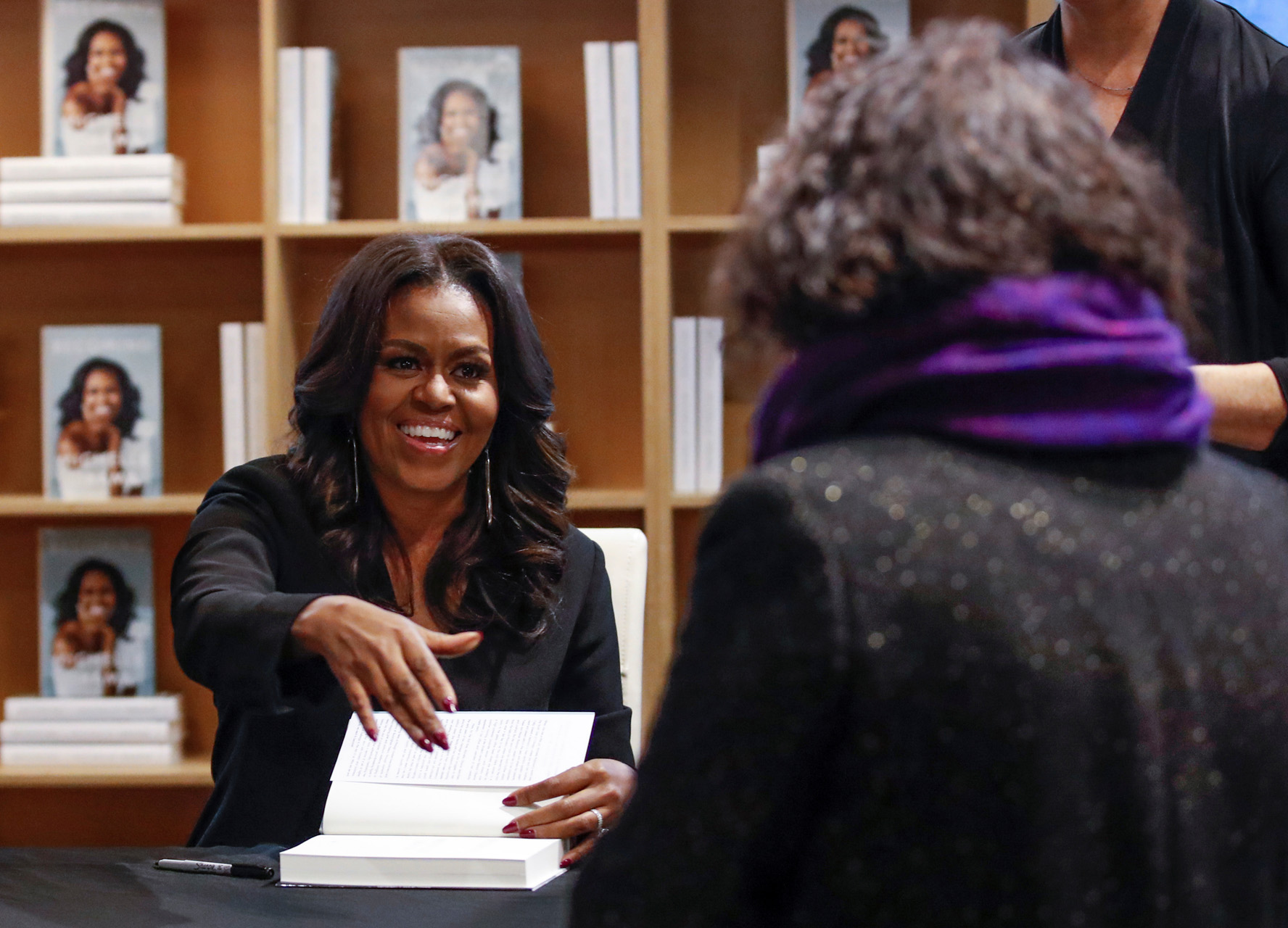 Former first lady Michelle Obama signs copies of her memoir "Becoming" at the Seminary Co-op Bookstore in Chicago, Illinois, U.S., November 13, 2018.  REUTERS
