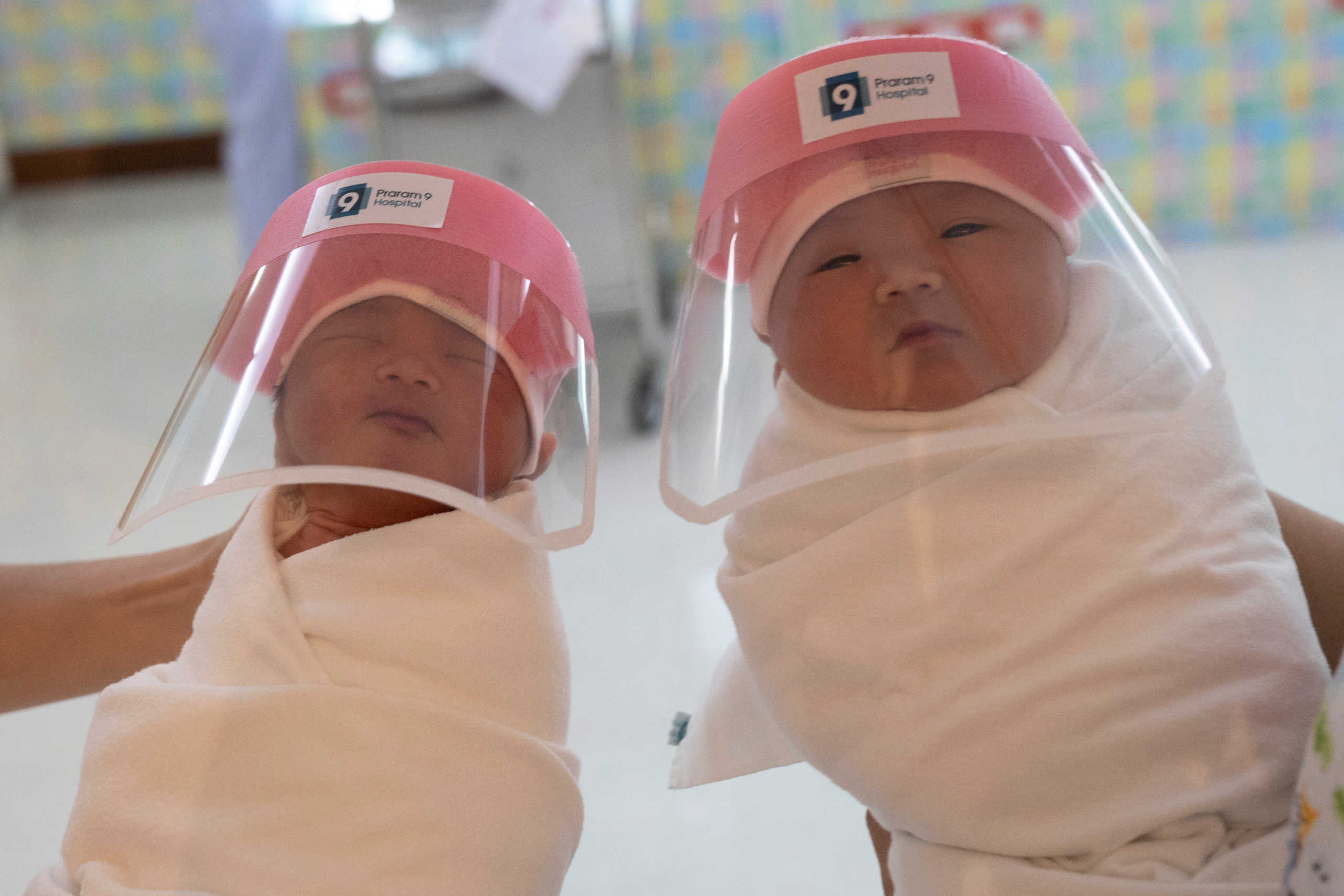 Nurses hold newborn babies wearing protective face shields during the coronavirus disease (COVID-19) outbreak at the Praram 9 hospital in Bangkok, Thailand, April 9, 2020. REUTERS