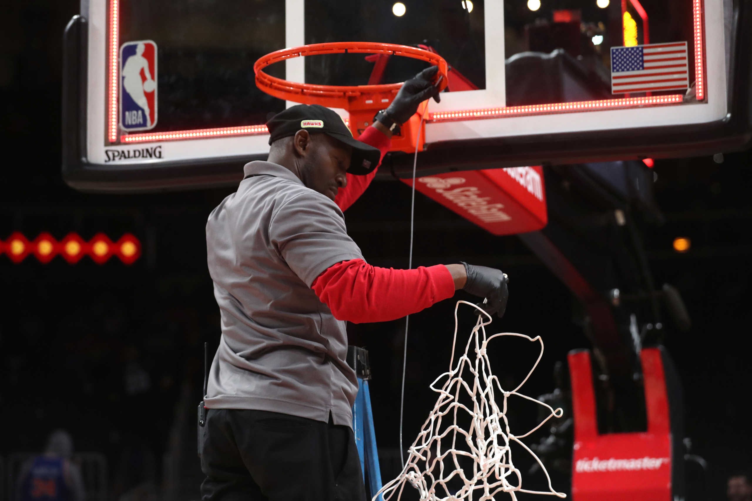 Mar 11, 2020; Atlanta, Georgia, USA; A State Farm Arena staff member removes the basketball net from a hoop after an Atlanta Hawks overtime loss to the New York Knicks at State Farm Arena. Mandatory Credit: Jason Getz-USA TODAY Sports
