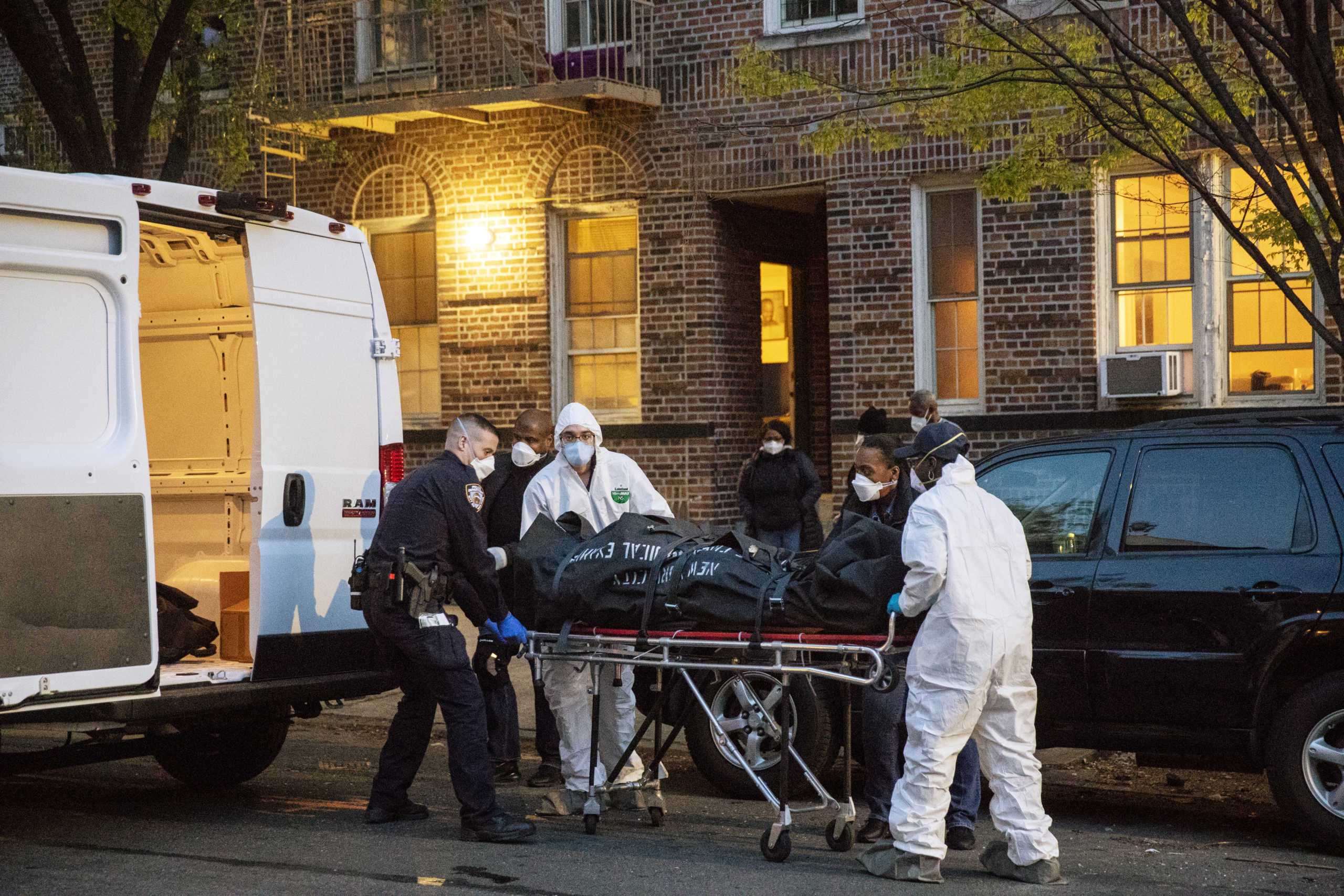 An officer from the New York Police Department helps workers carry a body out of a house amid the coronavirus disease (COVID-19) outbreak, in the Brooklyn borough of New York City, U.S., April 20, 2020. REUTERS