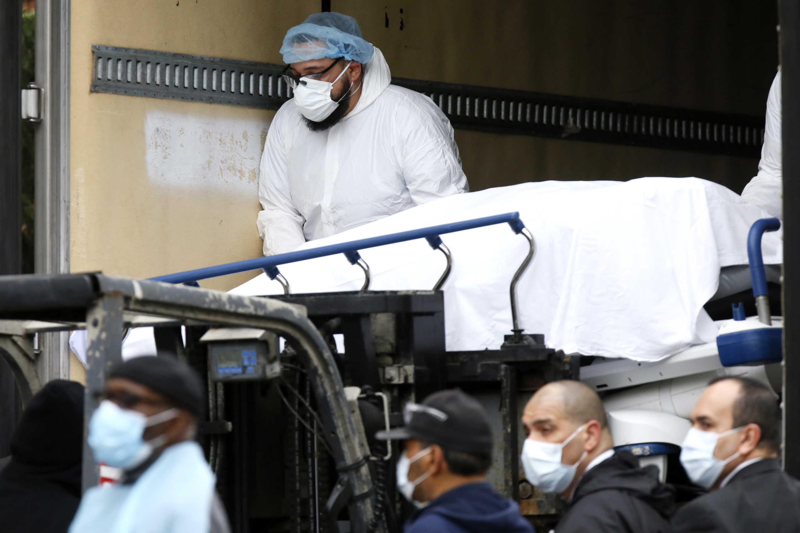 Workers load a deceased person into a truck trailer where bodies are being stored outside The Brooklyn Hospital Center during the coronavirus disease (COVID-19) outbreak in the Brooklyn borough of New York City, New York, U.S., March 31, 2020. REUTERS