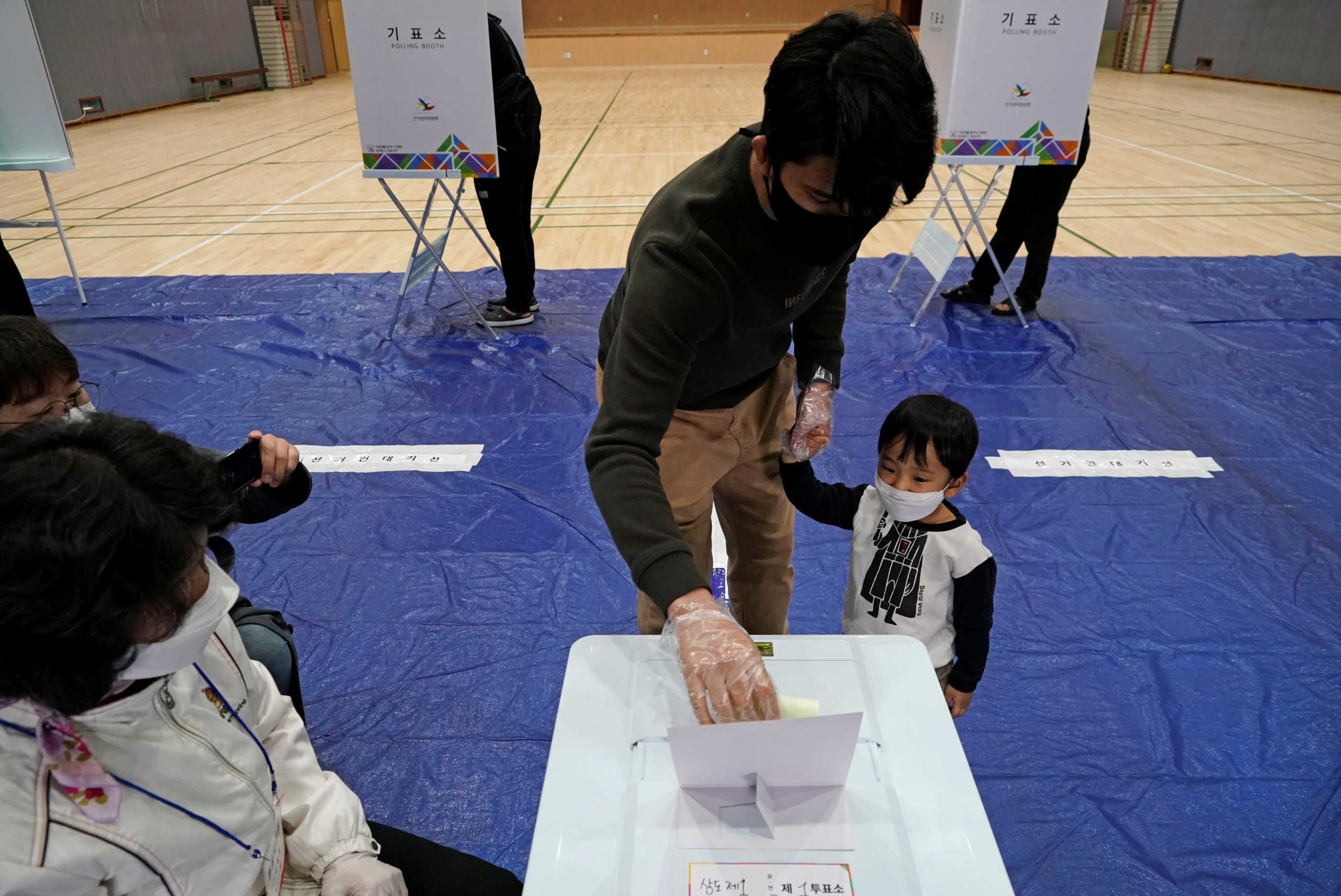 Voters wearing masks in an effort to prevent the spread of the coronavirus disease (COVID19) cast a ballot at a polling station during the parliamentary election in Seoul, South Korea, April 15, 2020. REUTERS