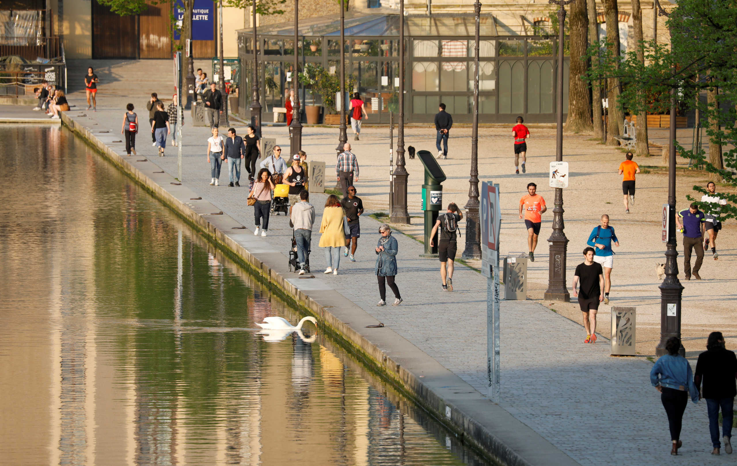 Residents enjoy the weather on the bank of the Canal de l'Ourcq during a lockdown imposed to slow the spread of the coronavirus disease (COVID-19) in Paris, France, April 12 2020. REUTERS