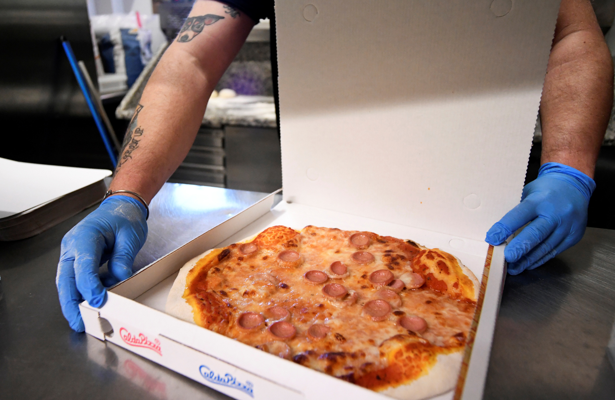 A man prepares a pizza at a restaurant, as Tuscany is the first italian region to allow restaurants to open only for takeout as the spread of the coronavirus disease (COVID-19) continues, in Castiglione della Pescaia, Italy, April 27, 2020. REUTERS