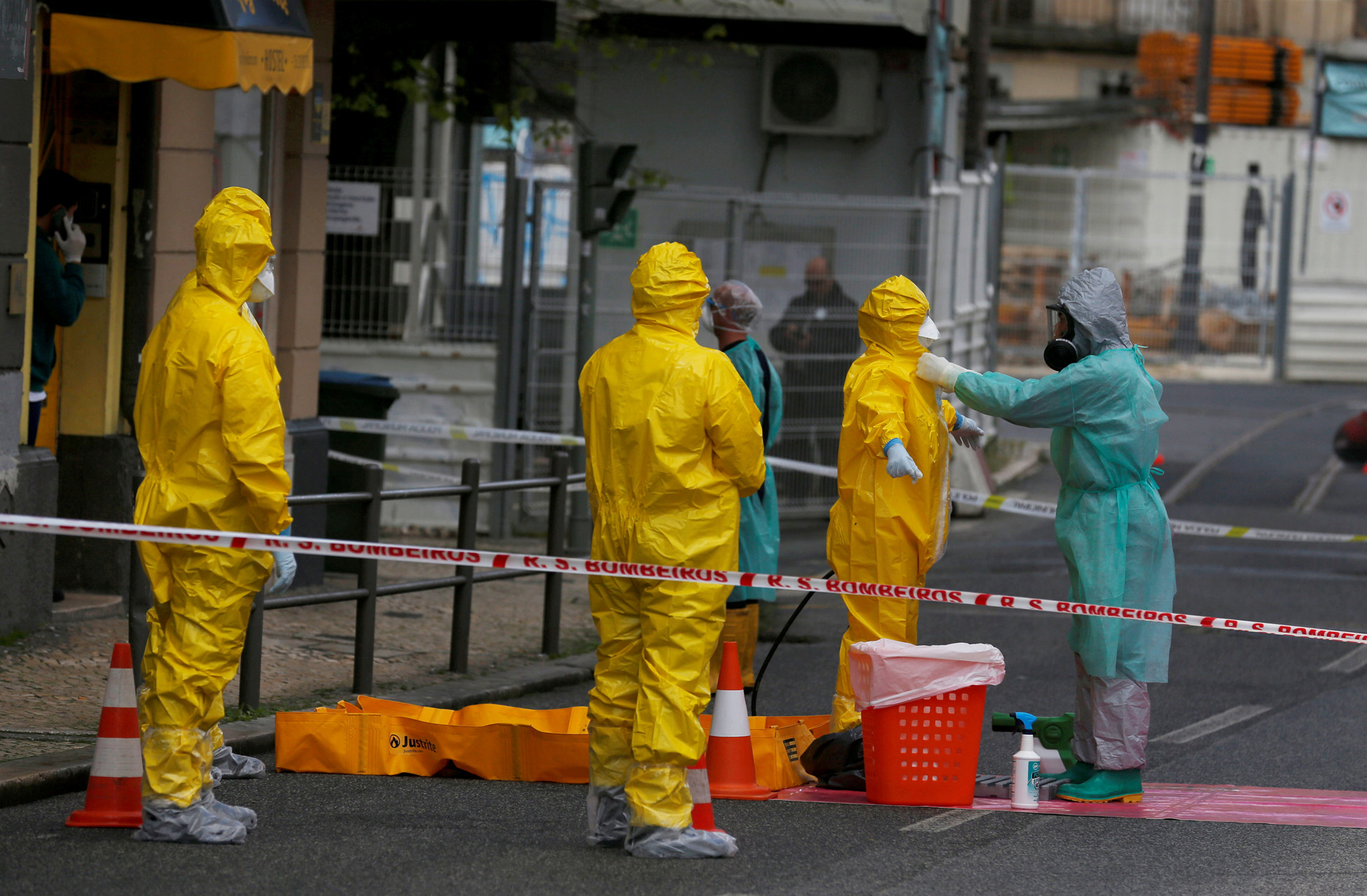 FILE PHOTO: Medical staff members take off their protective suits after evacuating asylum seekers from a hostel as the spread of the coronavirus disease (COVID-19) continues, in Lisbon, Portugal April 19, 2020.  REUTERS