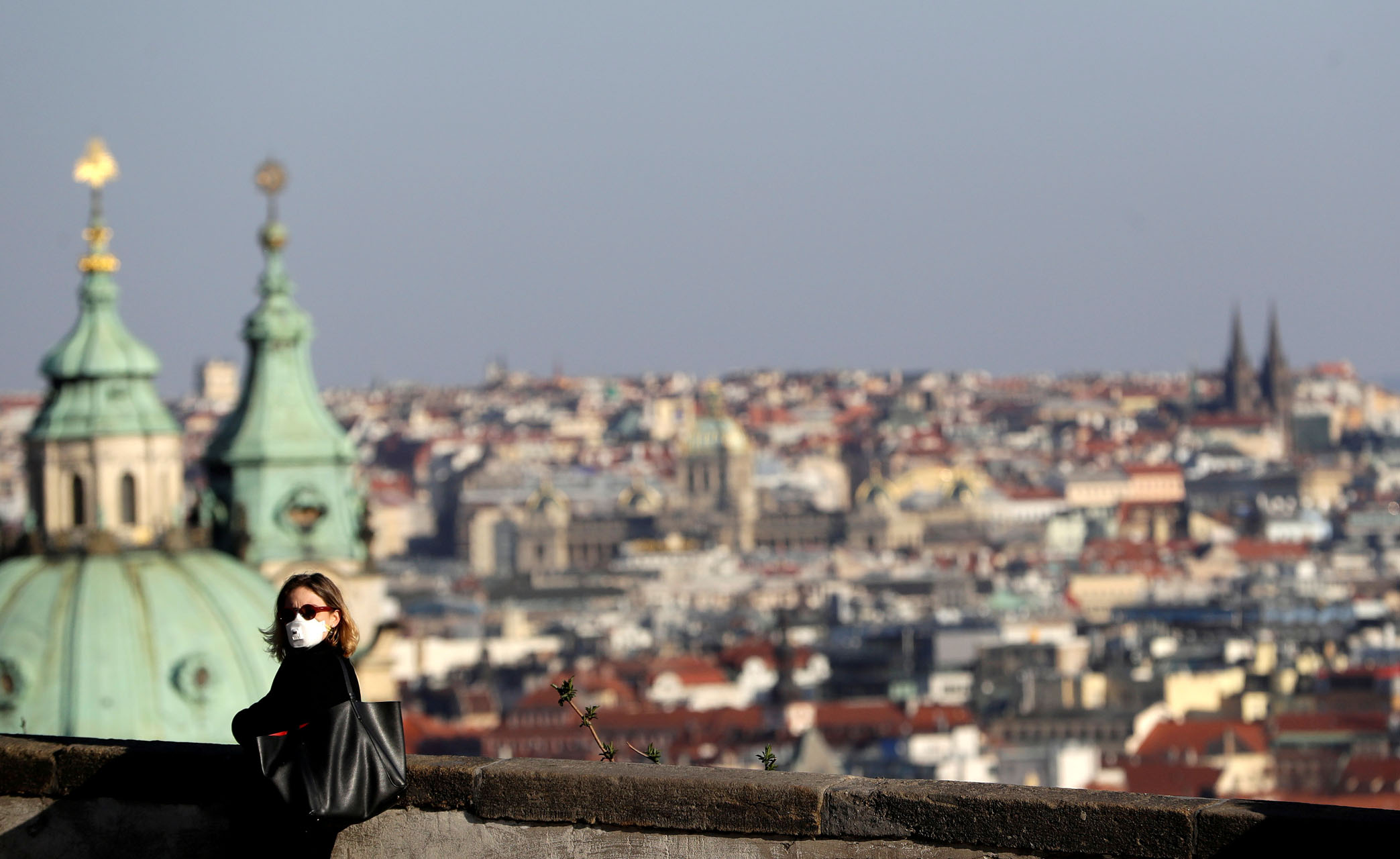 FILE PHOTO: A woman wearing a face mask stands at the Prague Castle as the spread of the coronavirus disease (COVID-19) continues in Prague, Czech Republic, March 24, 2020.  REUTERS