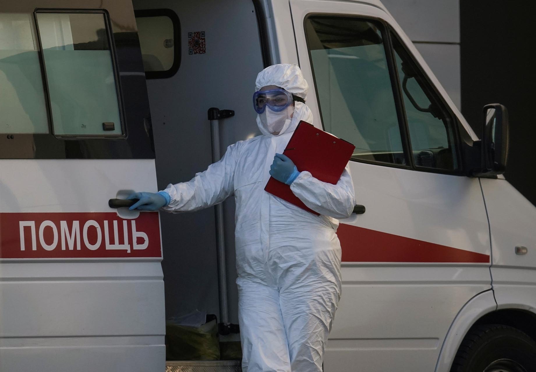 A medical specialist wearing protective gear stands near an ambulance outside a hospital for patients infected with the coronavirus disease (COVID-19) on the outskirts of Moscow, Russia April 12, 2020. REUTERS