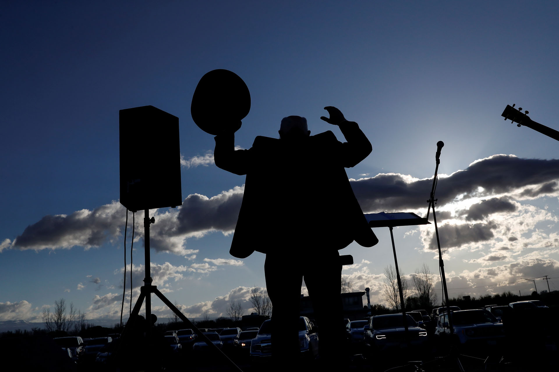 Pastor Terry Hedrick, from the Gunnison Valley Church of the Nazarene, is seen in silhouette preaching as parishioners sit in their cars during a drive-in Easter service via a radio transmission  organized by the Delta Ministries at the Tru Vu Drive In theater,  as the spread of the coronavirus disease (COVID-19) continues, in Delta, Colorado, U.S., April 12, 2020.  REUTERS
