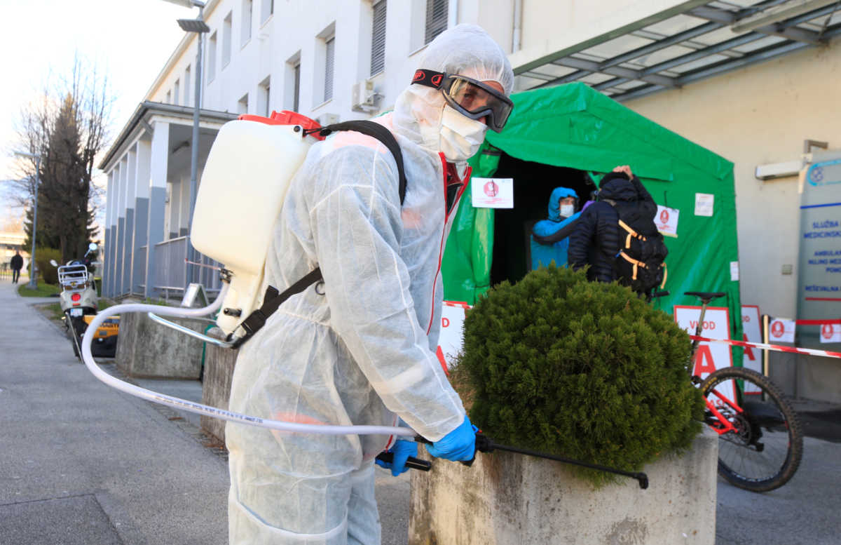 A worker sprays disinfectant to prevent the spread of coronavirus disease (COVID-19), outside the hospital in Kranj, Slovenia March 23, 2020. REUTERS