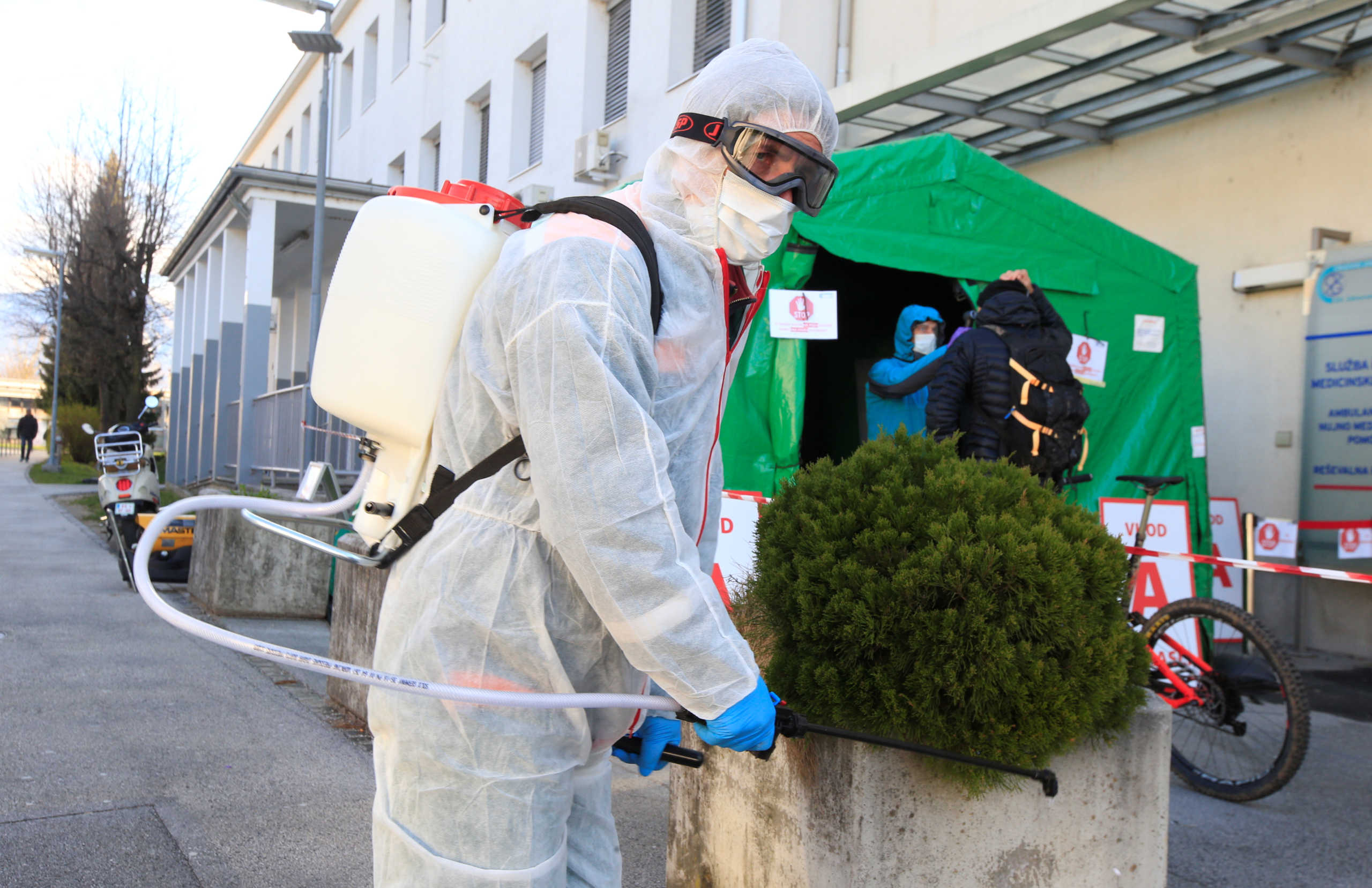 A worker sprays disinfectant to prevent the spread of coronavirus disease (COVID-19), outside the hospital in Kranj, Slovenia March 23, 2020. REUTERS
