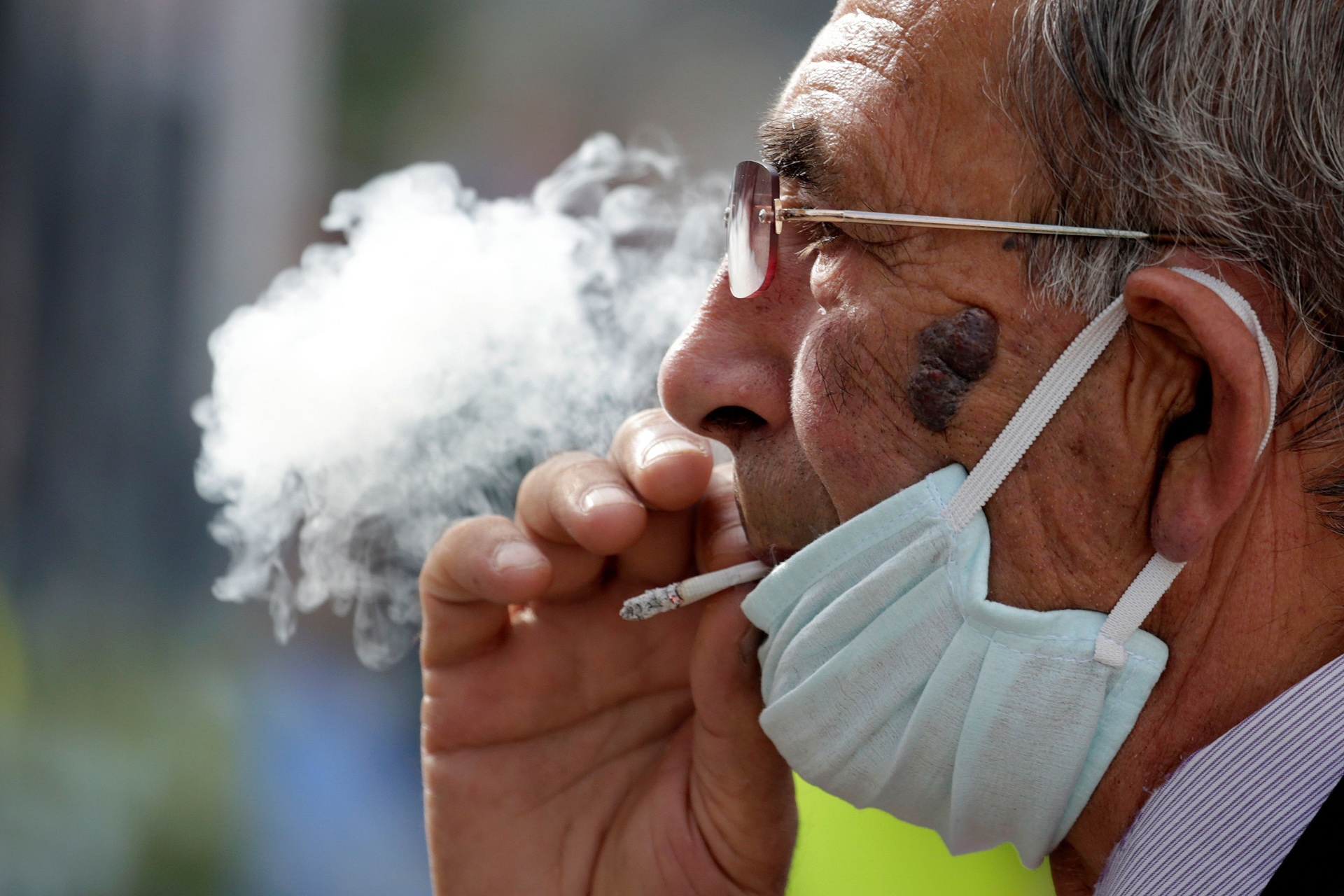 A man wearing a face mask smokes a cigaret, as Albanian authorities  take measures  to stop the spread of the coronavirus disease (COVID-19)  in Tirana, Albania April 6, 2020. REUTERS