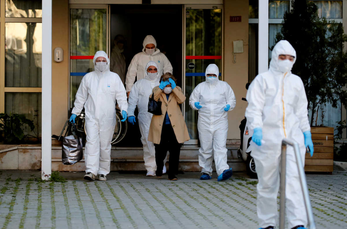 Paramedics escort a woman as she walks toward an ambulance during a two-day curfew which was imposed to prevent the spread of the coronavirus disease (COVID-19), in Istanbul, Turkey, April 12, 2020. REUTERS