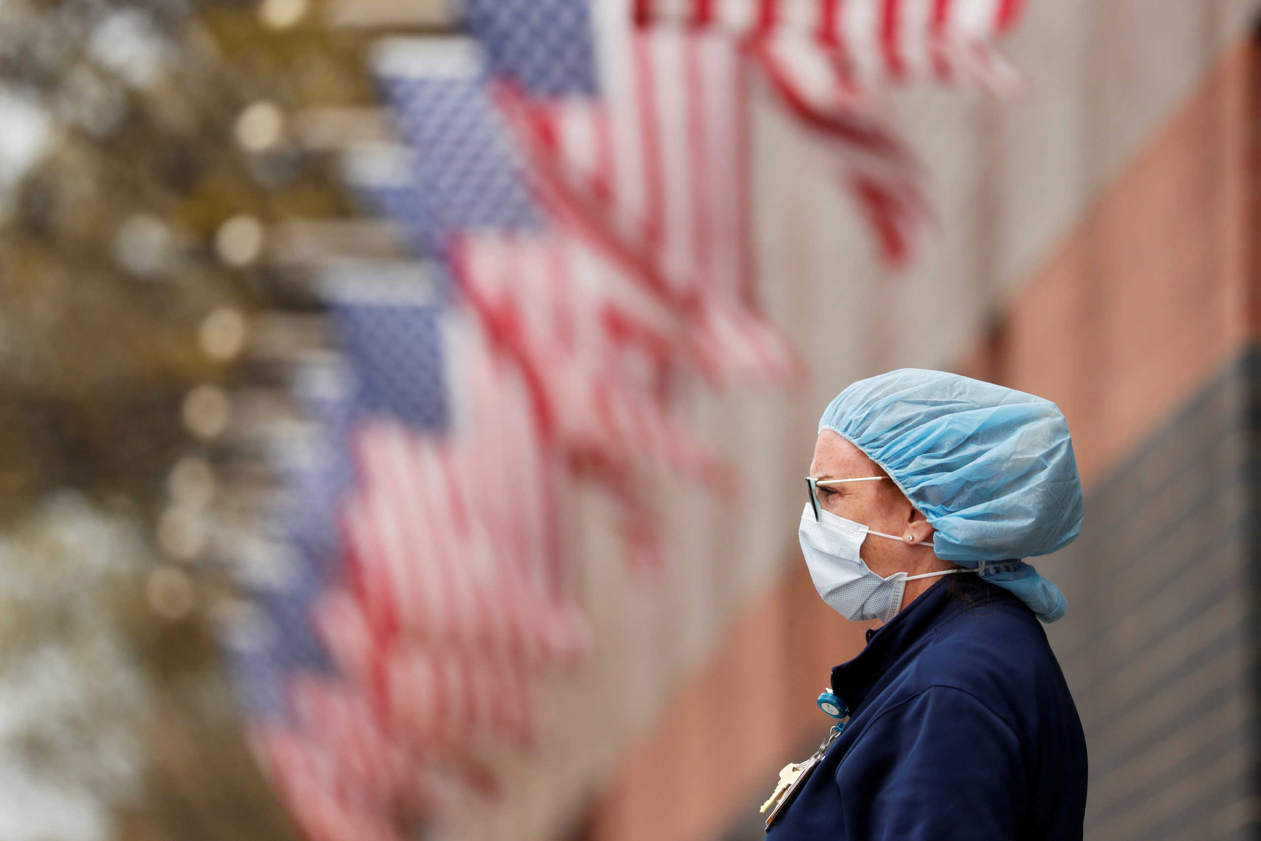 FILE PHOTO: A nurse wearing personal protective equipment watches an ambulance driving away outside of Elmhurst Hospital during the ongoing outbreak of the coronavirus disease (COVID-19) in the Queens borough of New York, U.S., April 20, 2020. REUTERS