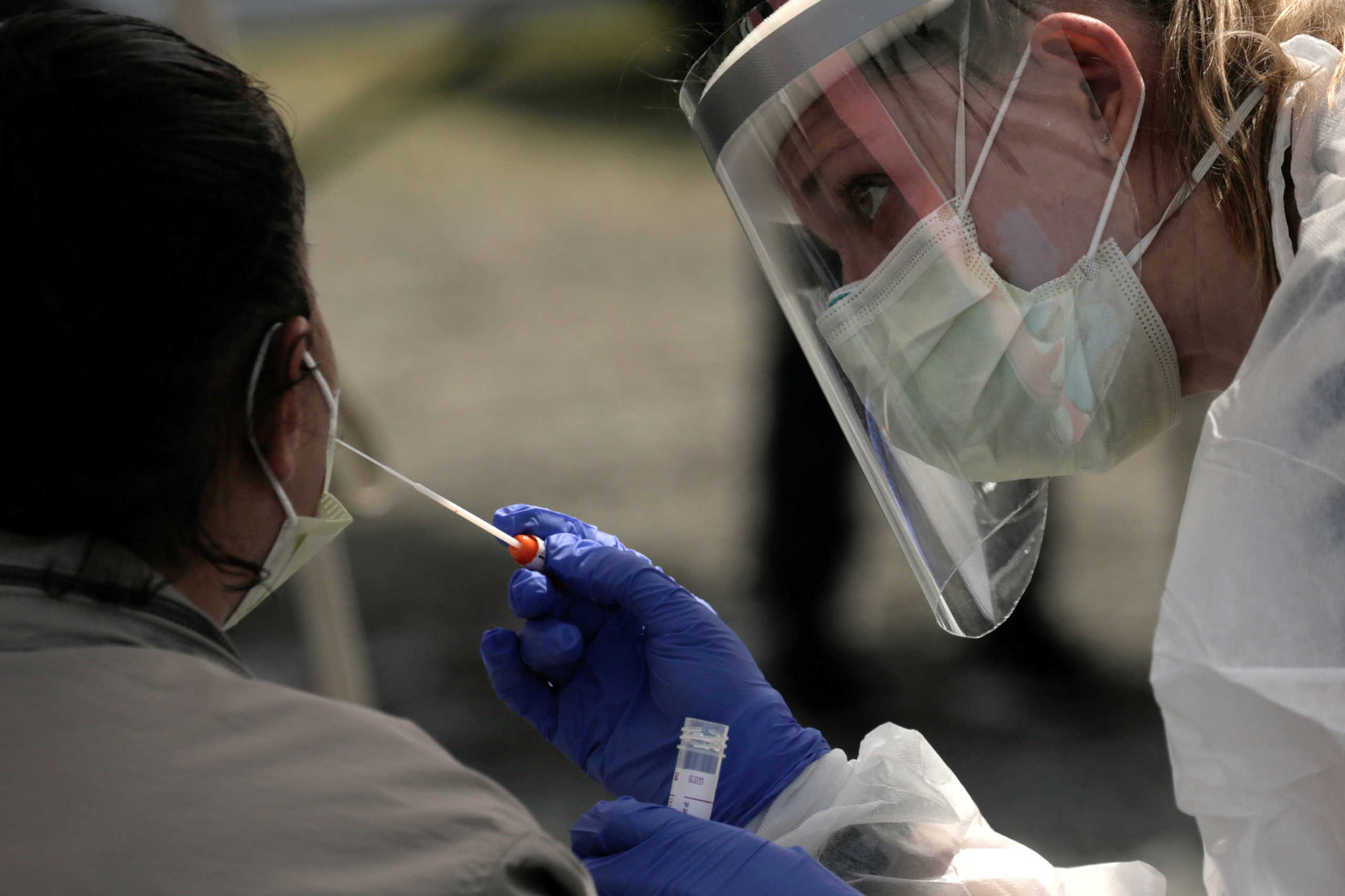 Physician Aliea Herbert administers a test for coronavirus disease (COVID-19) to a patient at Interbay Village, a village of tiny houses managed by the Low Income Housing Institute, at a mobile testing site run by Swedish Medical Center in Seattle, Washington, U.S. April 29, 2020.  REUTERS