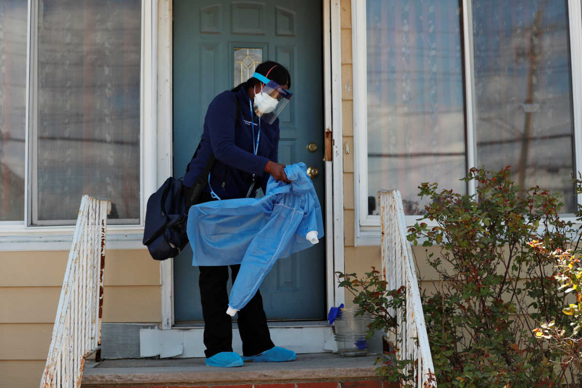 Home care nurse Flora Ajayi doffs personal protective equipment (PPE) she uses to protect herself and prevent cross-contamination while visiting a client during the ongoing coronavirus disease (COVID-19) outbreak, in the Queens borough of New York City, U.S., April 22, 2020. Picture taken April 22, 2020. REUTERS