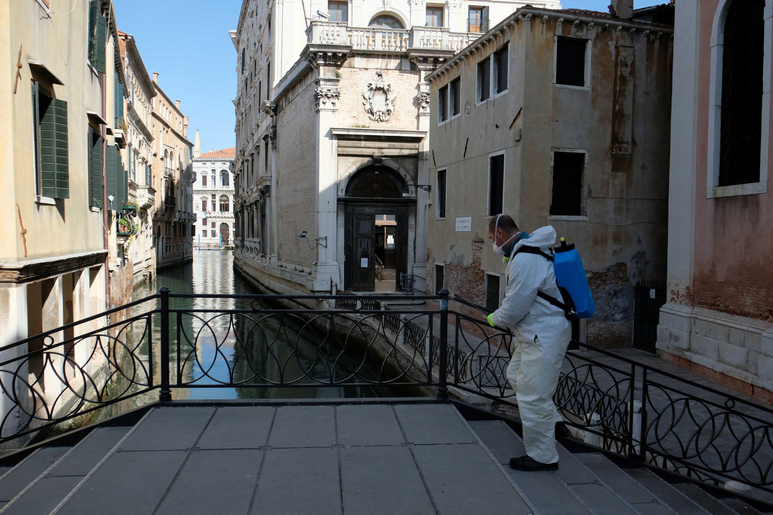 A man sanitises a bridge as the spread of the coronavirus disease (COVID-19) continues in Venice, Italy, April 16, 2020. REUTERS