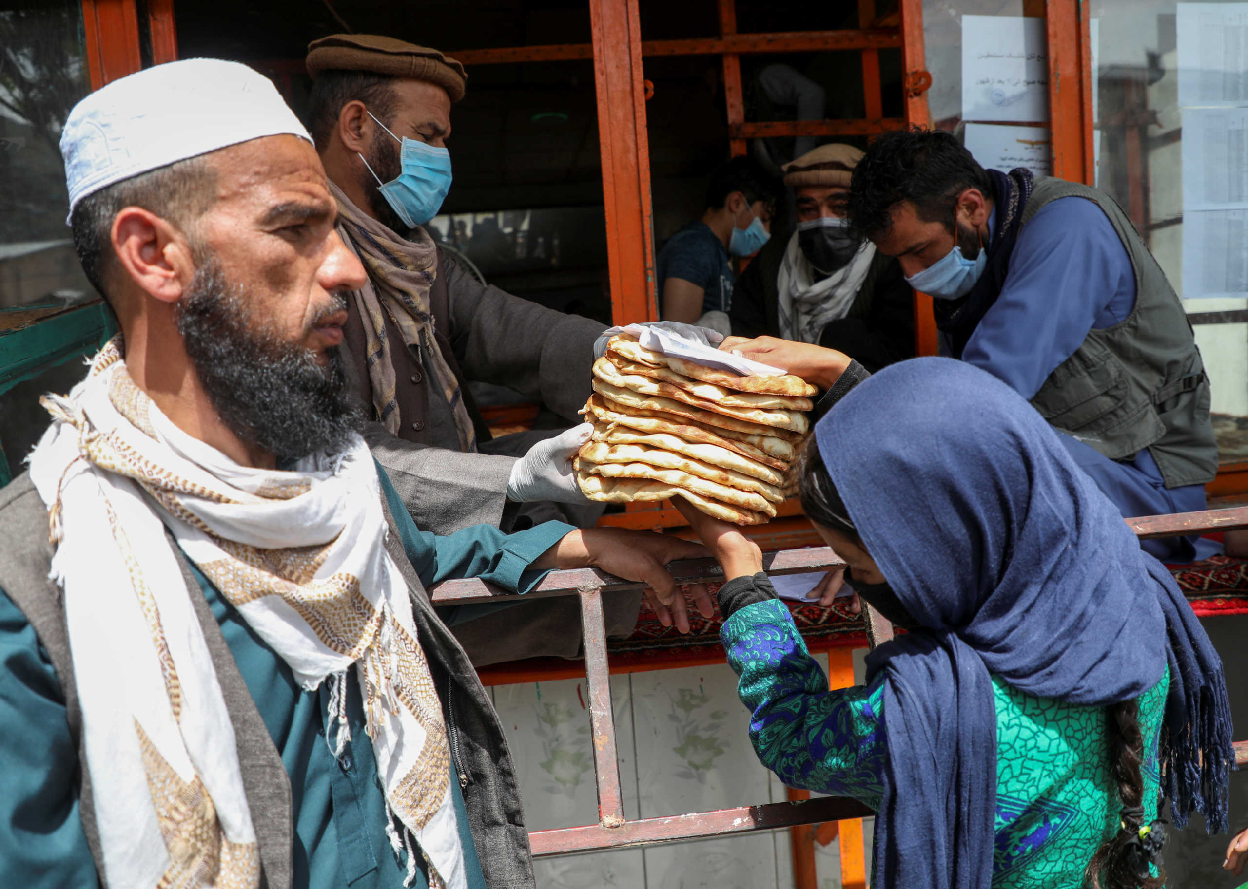An Afghan girl receives free bread distributed by the government, outside a bakery, during the coronavirus disease (COVID-19) outbreak in Kabul, Afghanistan May 3, 2020. Picture taken May 3, 2020. REUTERS