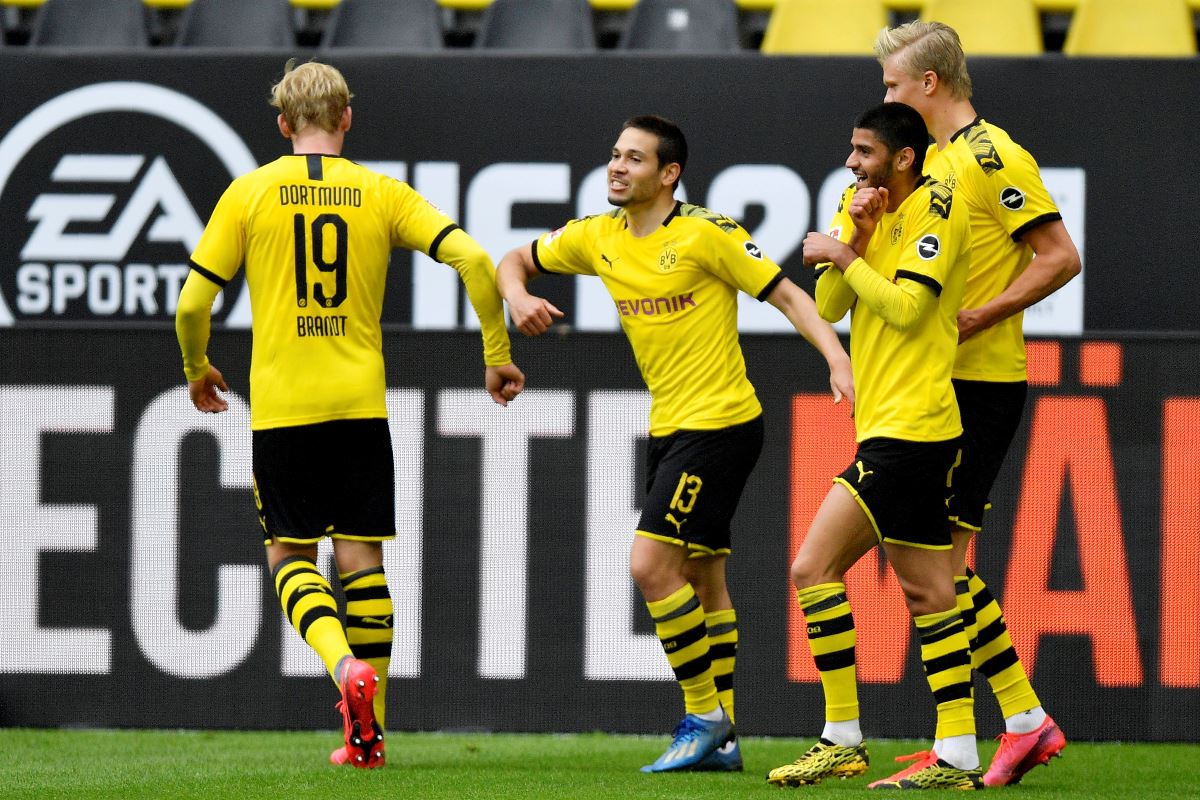 Soccer Football - Bundesliga - Borussia Dortmund v Schalke 04 - Signal Iduna Park, Dortmund, Germany - May 16, 2020 Dortmund's Raphael Guerreiro celebrates scoring their second goal with teammates as play resumes behind closed doors following the outbreak of the coronavirus disease (COVID-19) Martin Meissner