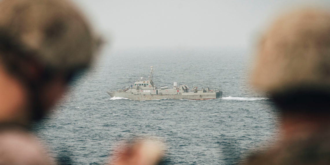 Marines onboard the amphibious transport dock ship USS John P. Murtha (LPD 26) observe an Iranian fast attack craft as it transits the Strait of Hormuz, off Oman, in this undated handout picture released by U.S. Navy on August 12, 2019. Donald Holbert
