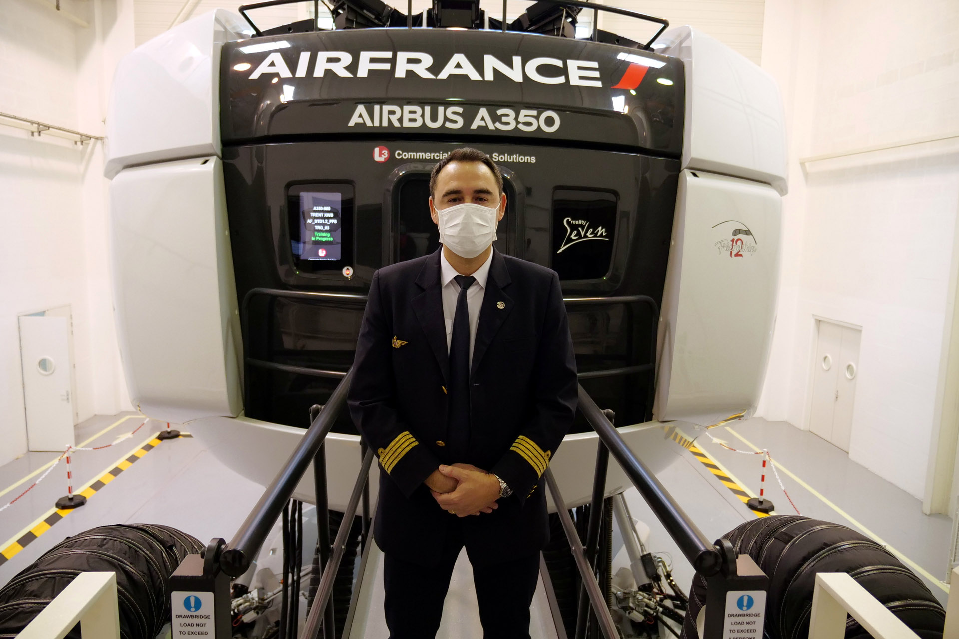 Jean Fernandez, executive vice-president for flight operations at Air France, wears a protective mask as he poses in front of an Airbus A350 flight simulator at an Air France training centre near Charles de Gaulle airport amid the coronavirus disease (COVID-19) outbreak near Paris, France, May 15, 2020. REUTERS