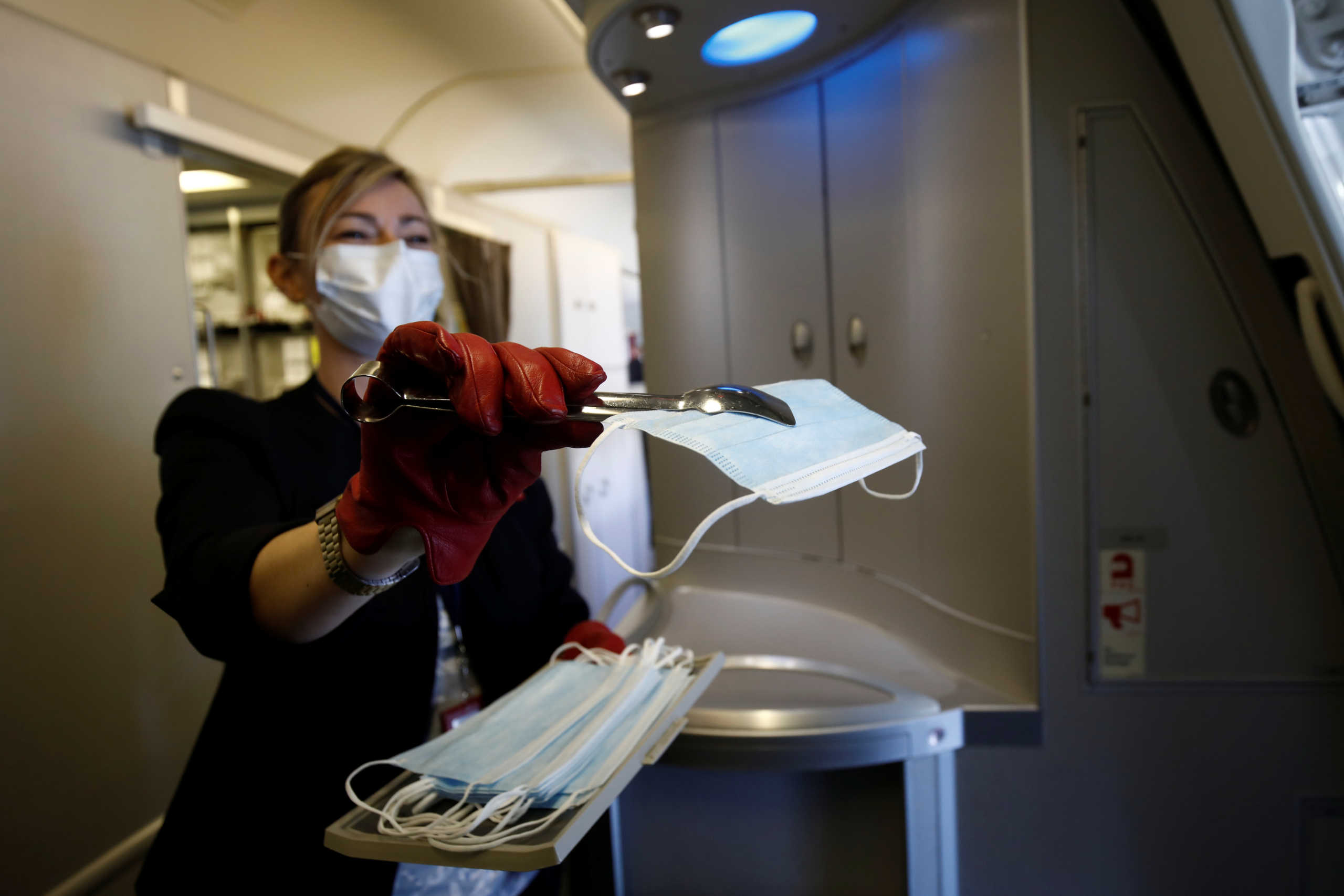 Air France flight crew members wearing protective face masks distribute face masks to passengers  at Paris Charles de Gaulle airport in Roissy-en-France during the outbreak of the coronavirus disease (COVID-19) in France, May 6, 2020. REUTERS