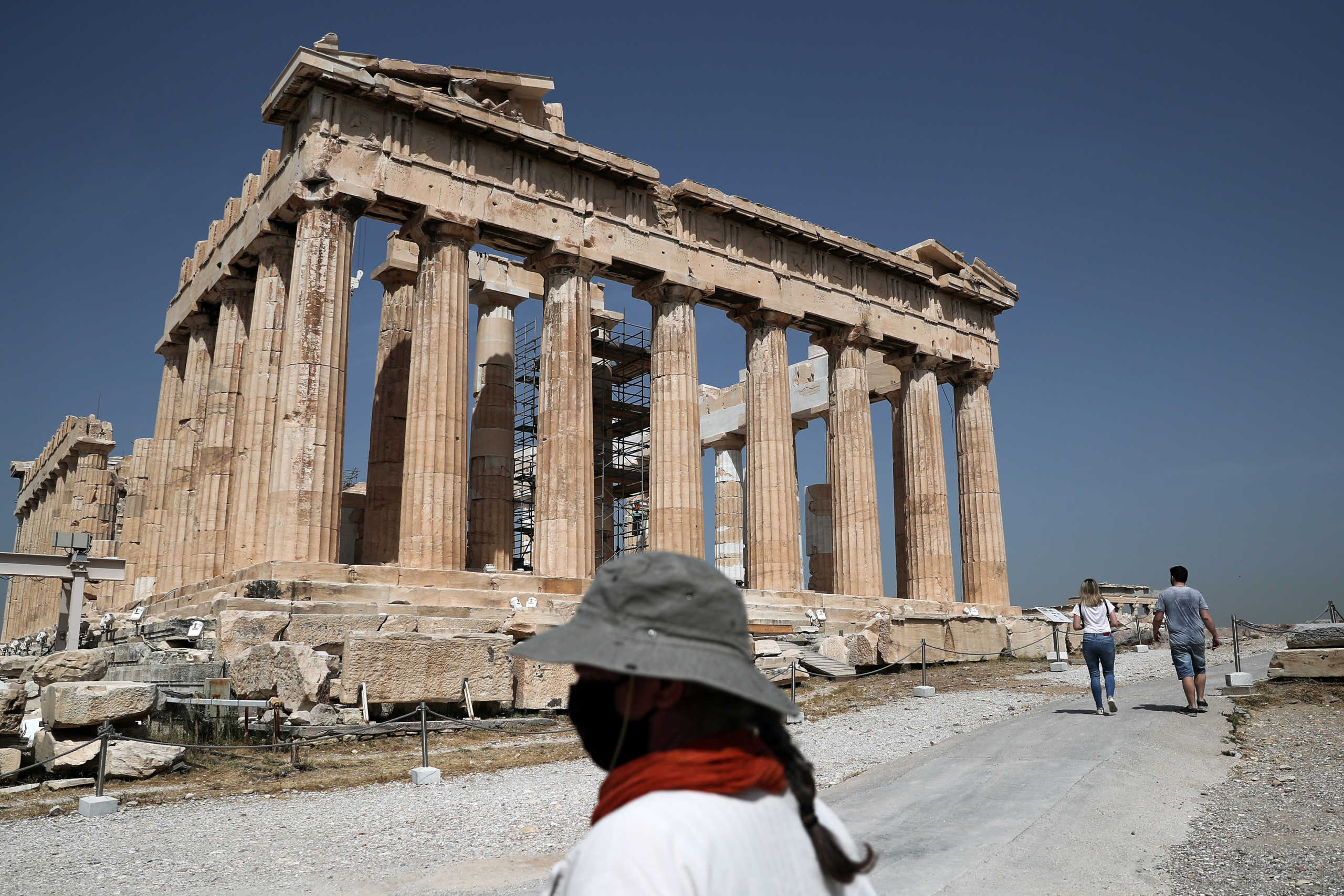 A Culture ministry employee wearing a face mask stands in front of the Parthenon temple as the Acropolis archaeological site opens to visitors, following the easing of measures against the spread of the coronavirus disease (COVID-19), in Athens, Greece, May 18, 2020. REUTERS