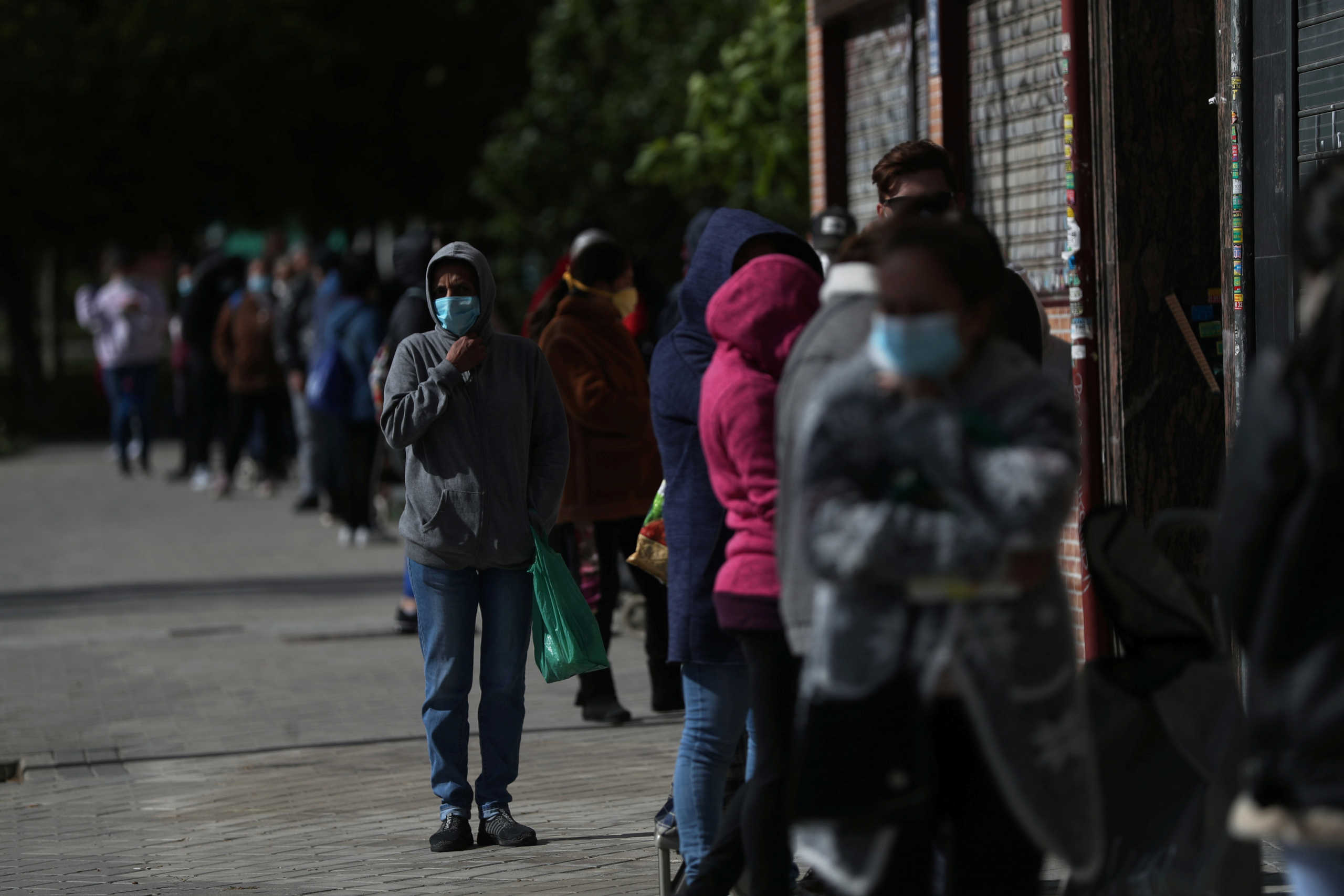 People queue to receive donated food from volunteers of Vecinos Parque Aluche association as the spread of the coronavirus disease (COVID-19) continues in Madrid, Spain, May 16, 2020. REUTERS