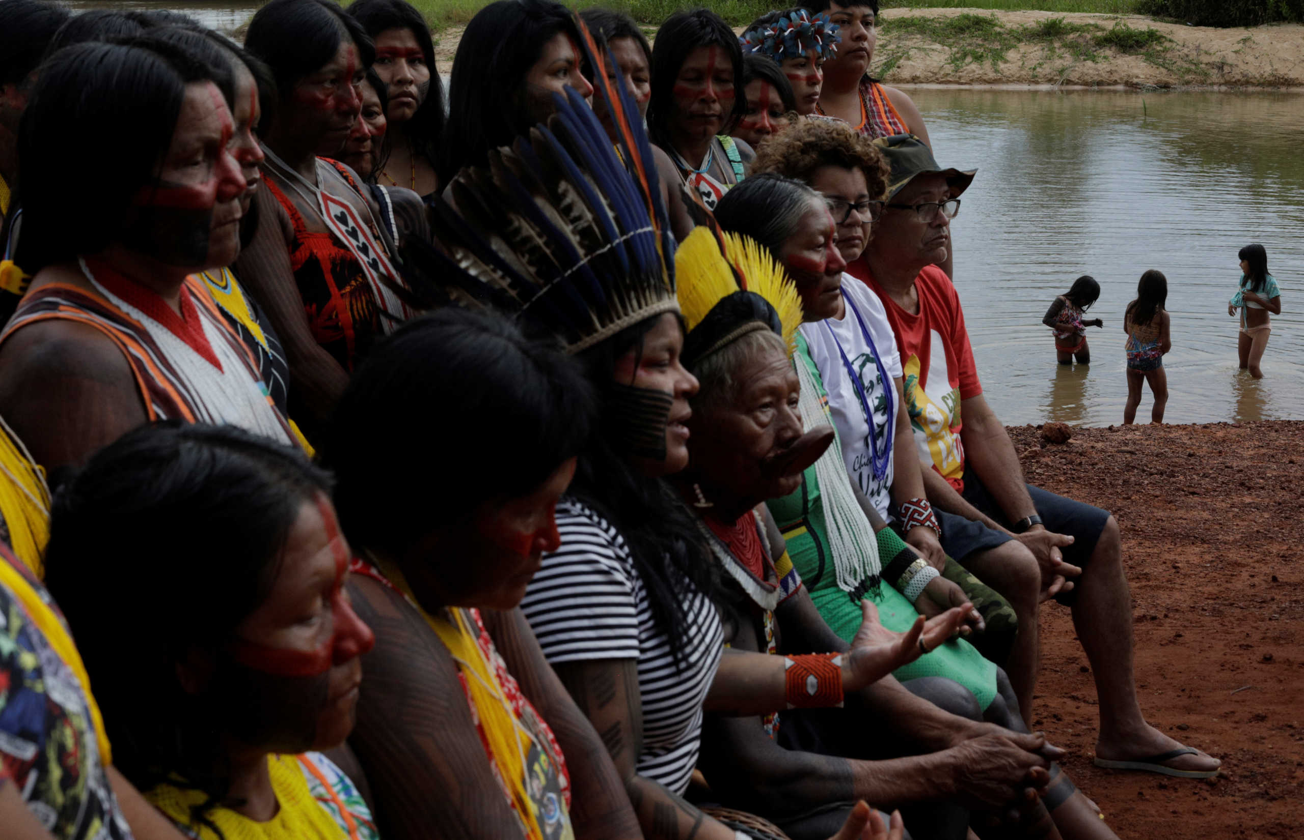 Kids play on Xingu River during a joint declaration to the media by Indigenous leaders Cacique Raoni of Kayapo tribe (C) and Sonia Guajajara (3rd L), and Angela Mendes (2nd R), daughter of late environmentalist Chico Mendes, during a four-day pow wow in Piaracu village, in Xingu Indigenous Park, near Sao Jose do Xingu, Mato Grosso state, Brazil, January 15, 2020. REUTERS