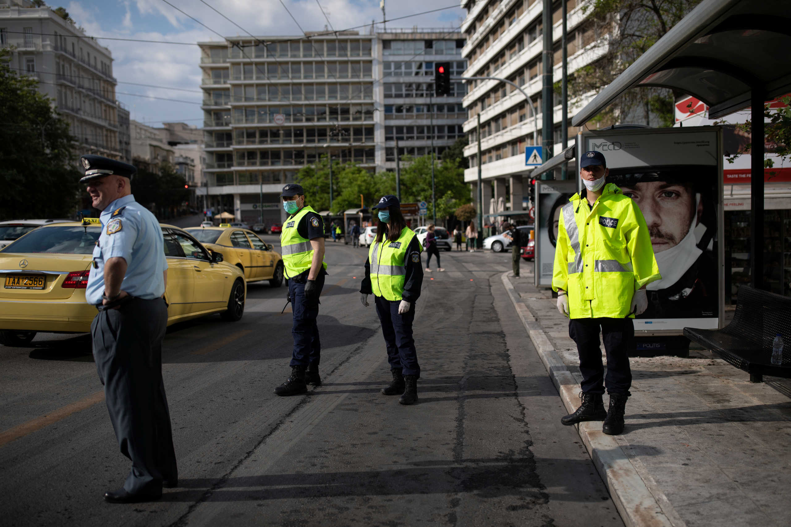 Police officers wait to perform checks on bus passengers following the obligatory use of protective face masks, on the first day of easing of a nationwide lockdown against the spread of coronavirus disease (COVID-19), in Athens, Greece, May 4, 2020. REUTERS
