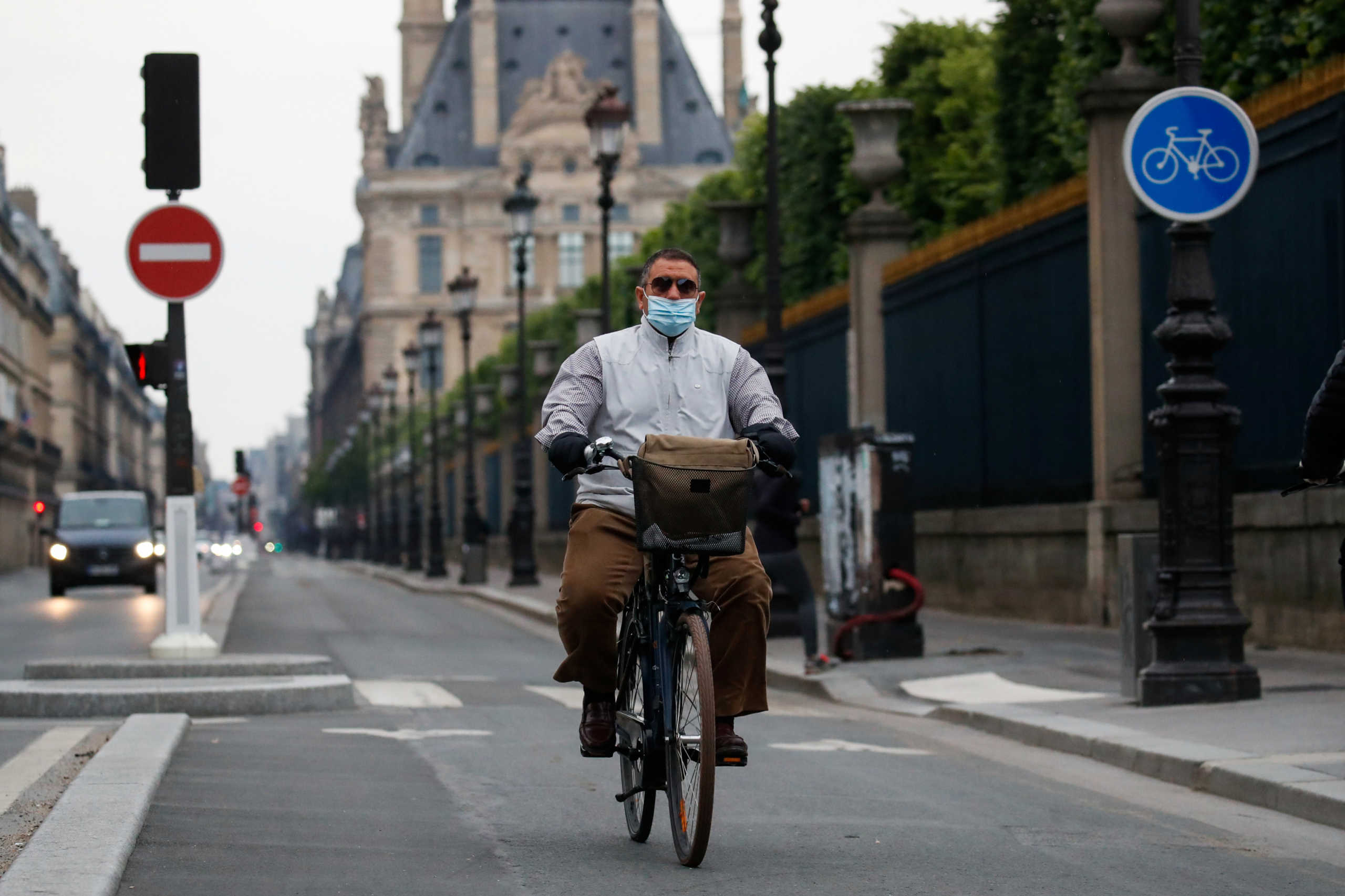 A man wearing a protective face mask rides a bike in the Rue de Rivoli in Paris during the outbreak of the coronavirus disease (COVID-19) in France, May 5, 2020. REUTERS