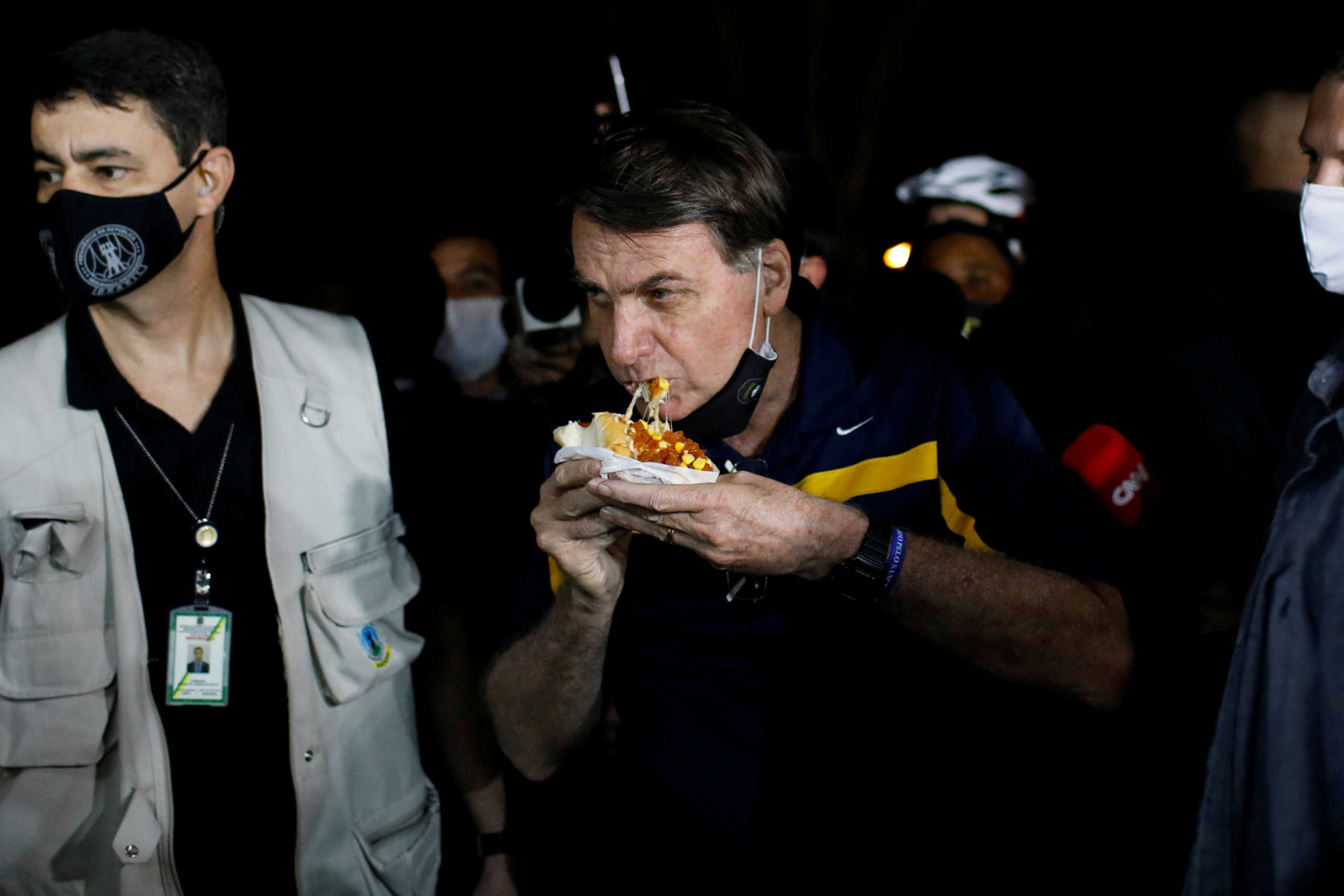 Brazil's President Jair Bolsonaro eats a hotdog in a street cafeteria, amid the coronavirus disease (COVID-19) outbreak, in Brasilia, Brazil May 23, 2020. REUTERS