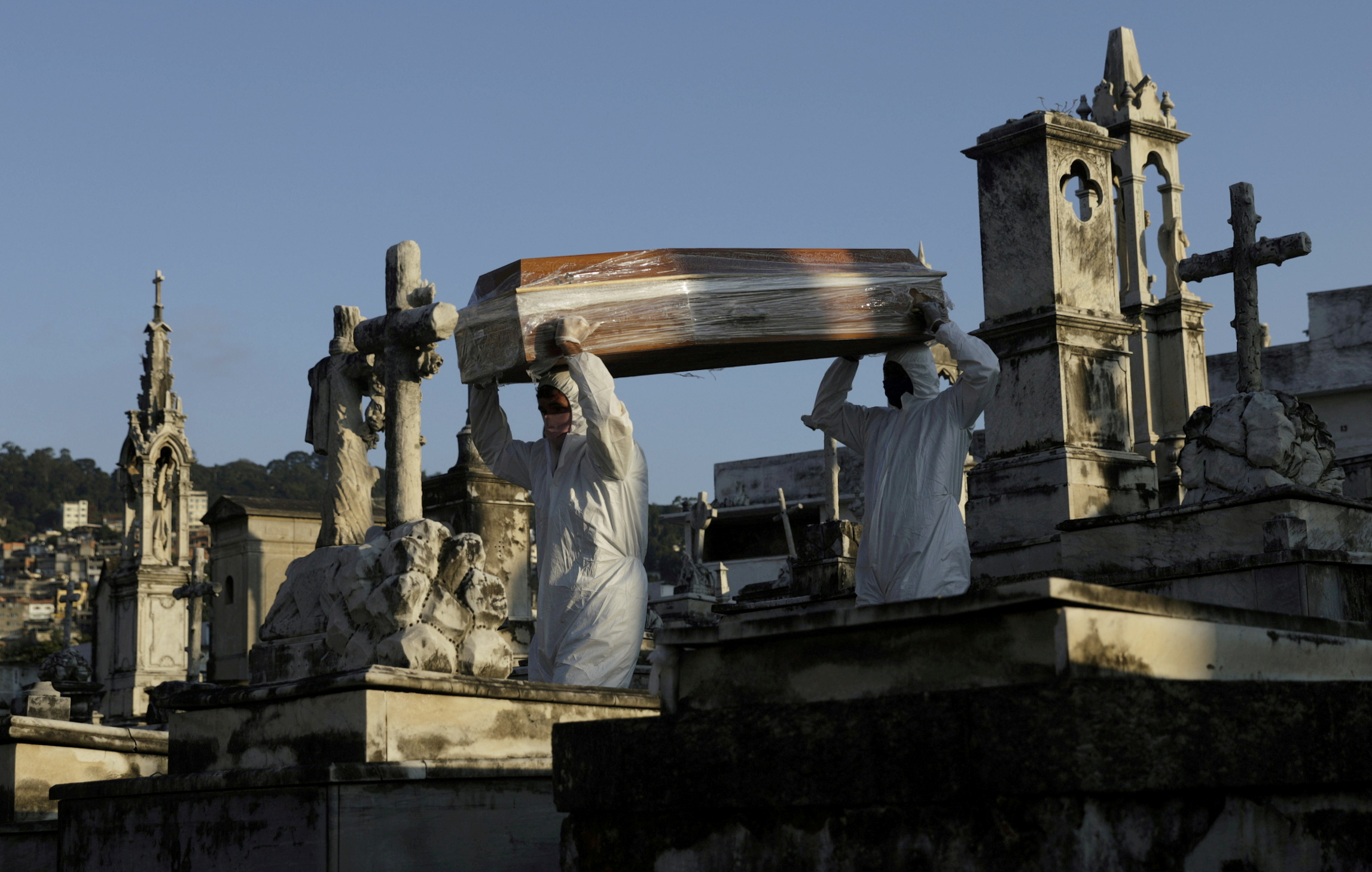 FILE PHOTO: Gravediggers carry the coffin of Antonia Rodrigues during her funeral who passed away from the coronavirus disease (COVID-19), in Rio de Janeiro, Brazil, May 18, 2020.  REUTERS
