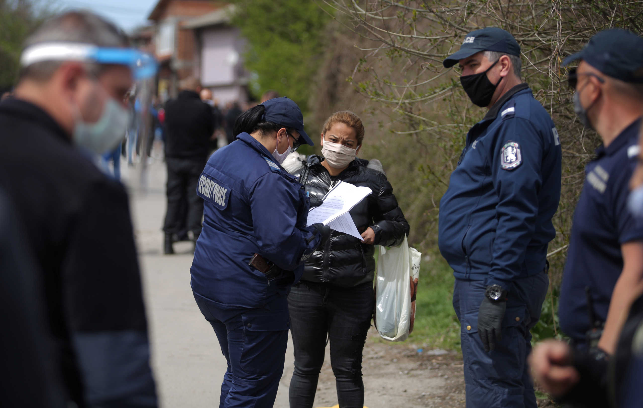 A policewoman checks the papers of a woman at the biggest Roma-populated district in Sofia, Bulgaria, April 17, 2020. Several dozens of Roma people gathered to express concern of losing their jobs due to the measures for restricting movement introduced in their neighbourhood on Thursday in an attempt to prevent the spread of coronavirus disease (COVID-19) outbreak. REUTERS