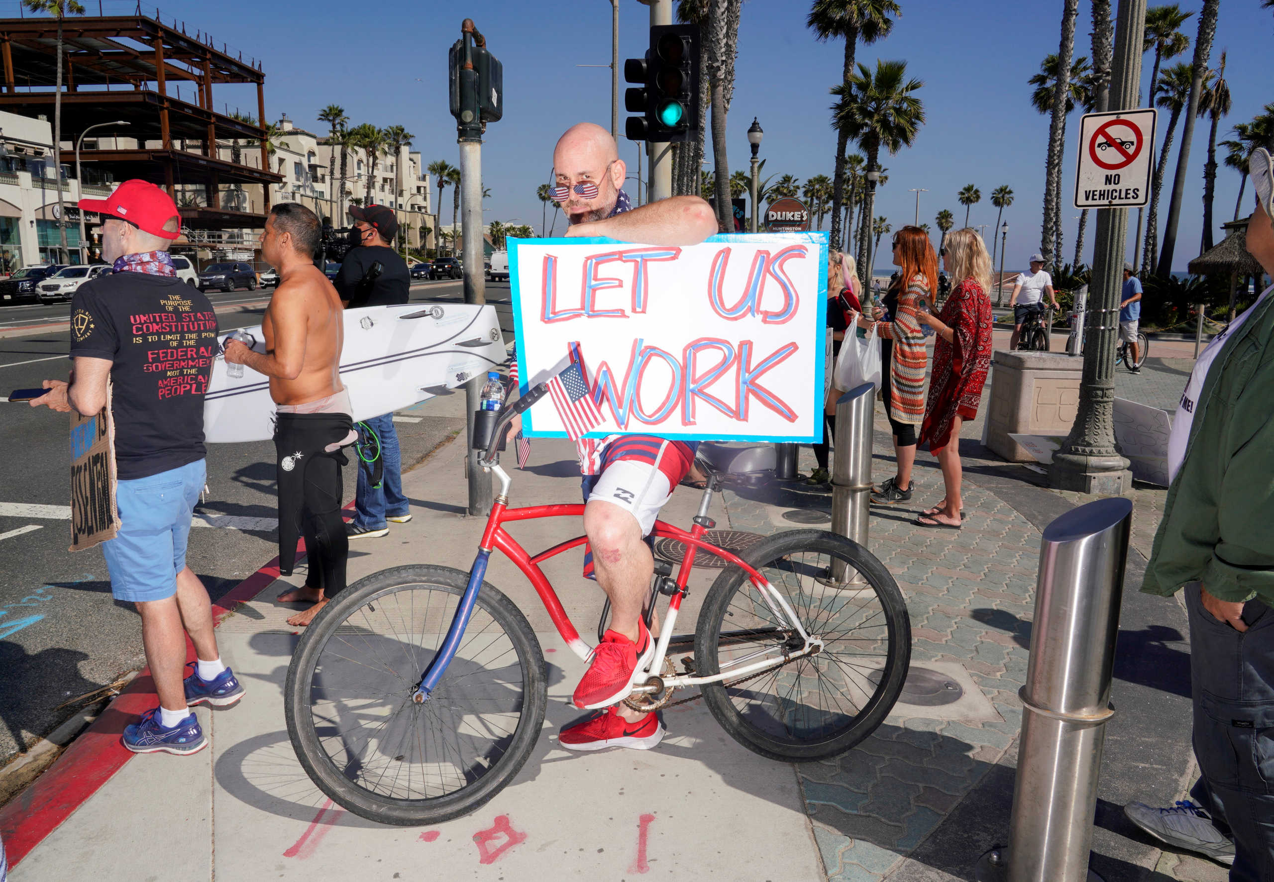 Levi Smiley of Huntington Beach, who has recently been furloughed, waits to enter the intersection near Huntington Beach Pier as he protests Gov. Gavin Newsom?s order to temporarily close state and local beaches in Orange County, during the outbreak of the coronavirus disease (COVID-19) in Huntington Beach, California, U.S., May 1, 2020.      REUTERS