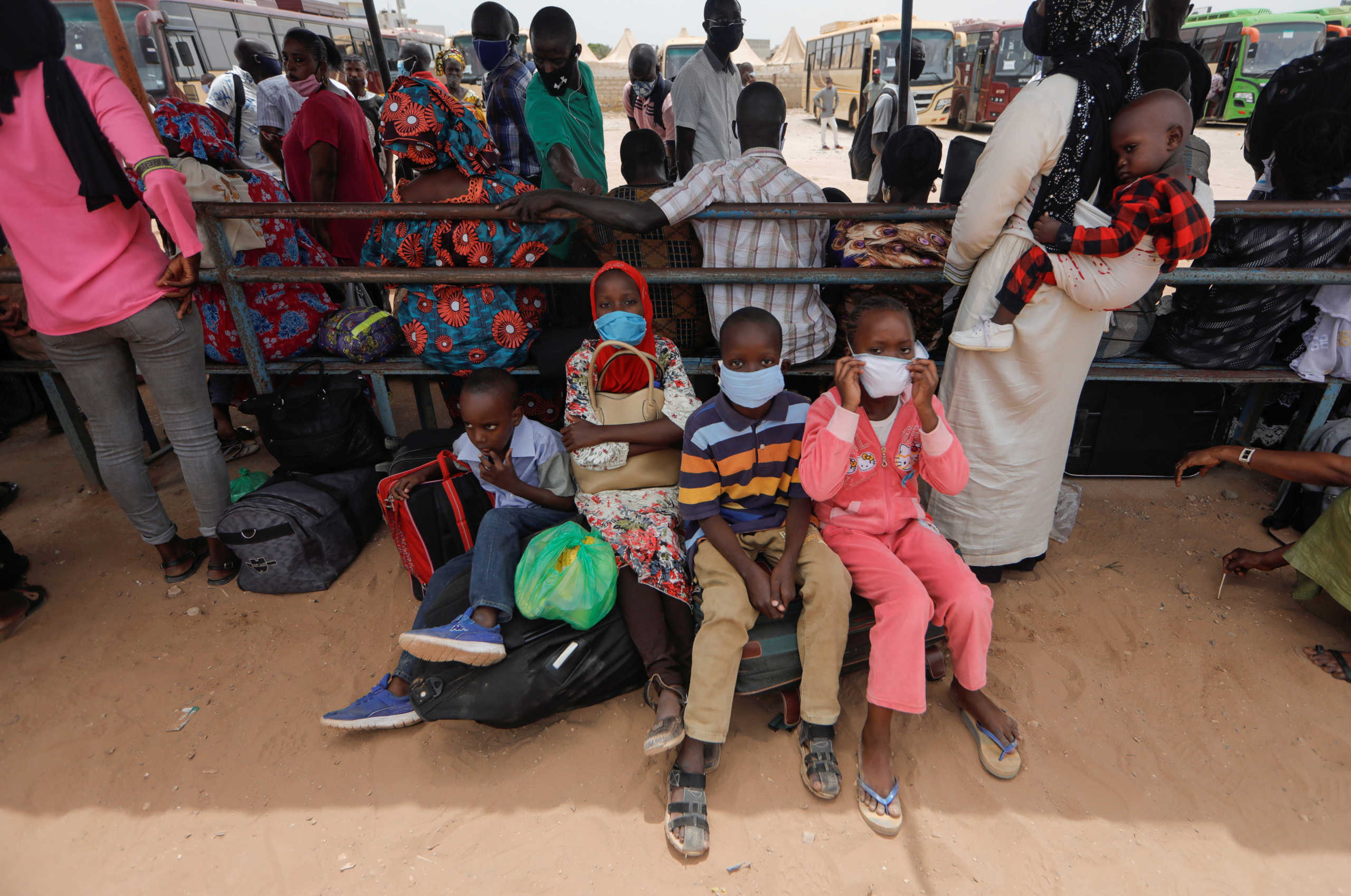 Teachers' children wait with their mothers' colleagues to board a government chartered buses, to go back to schools of countryside towns, scheduled to reopen next week, amid travel bans between regions due to the coronavirus disease (COVID-19) outbreak, in Dakar, Senegal May 27, 2020. REUTERS