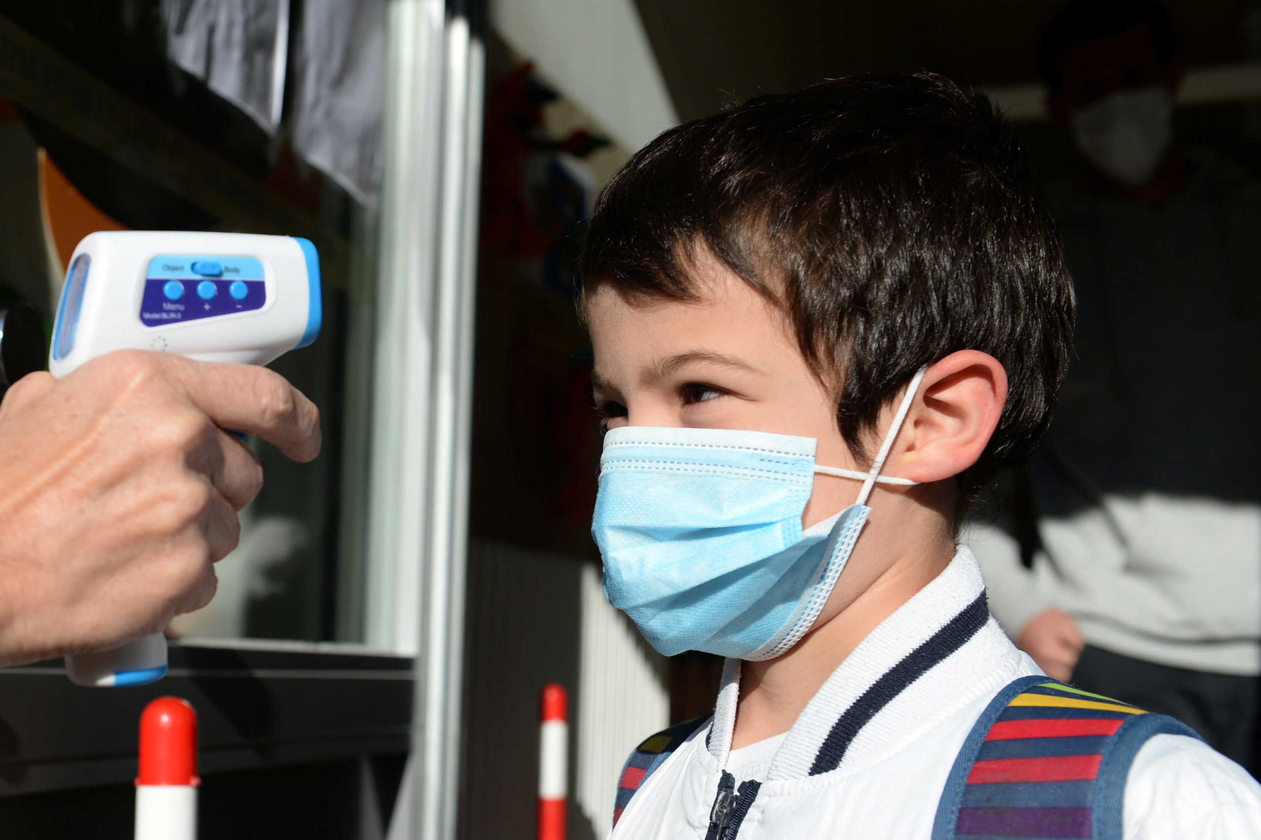 A teacher takes the children's temperature at the entrance of a flemish primary school during its reopening as a small part of Belgian children head back to their schools with new rules and social distancing during the outbreak of the coronavirus disease (COVID-19) in Brussels, Belgium May 15, 2020.REUTERS