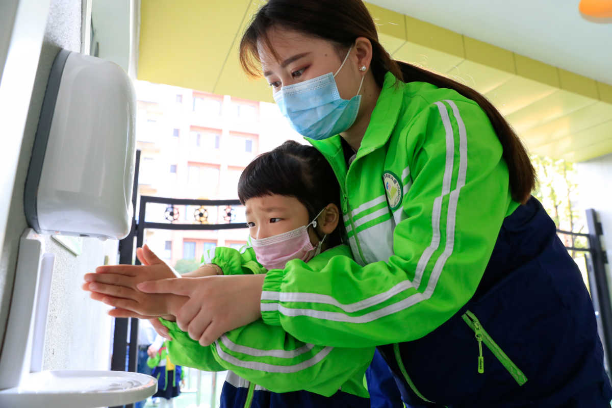 A child wearing a face mask cleans her hands at a kindergarten that has resumed operation following the coronavirus disease (COVID-19) outbreak, in Hefei, Anhui province, China May 11, 2020. China Daily via REUTERS  ATTENTION EDITORS - THIS IMAGE WAS PROVIDED BY A THIRD PARTY. CHINA OUT.