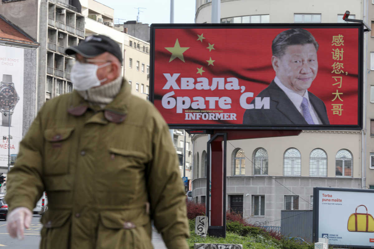 FILE PHOTO: A man wearing a protective mask passes by a billboard depicting Chinese President Xi Jinping as the spread of the coronavirus disease (COVID-19) continues in Belgrade, Serbia, April 1, 2020. The text on the billboard reads "Thanks, brother Xi". Picture taken April 1, 2020. REUTERS