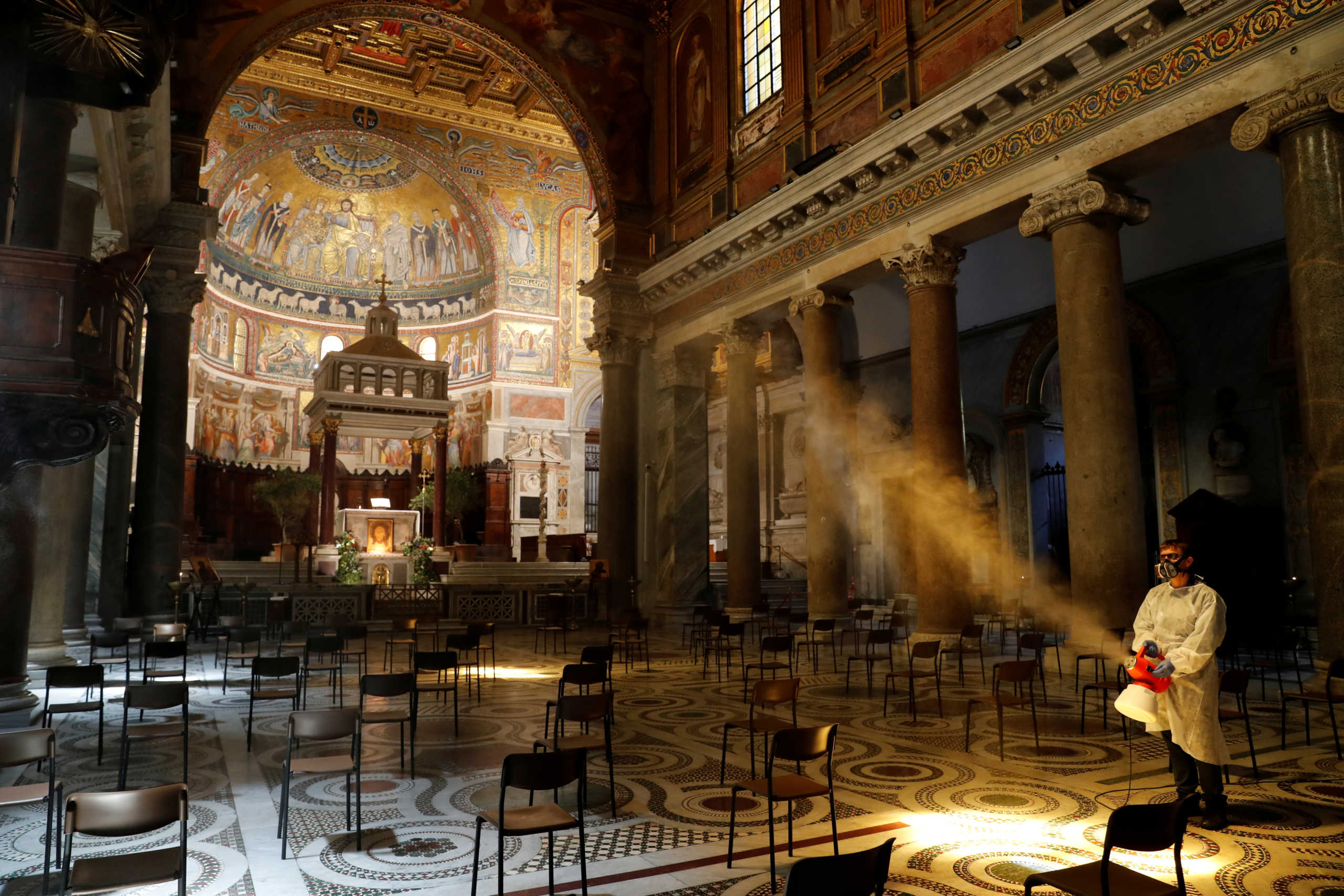 A man disinfects the Santa Maria in Trastevere Basilica, during the coronavirus disease (COVID-19) outbreak, in Rome, Italy, May 11, 2020. REUTERS