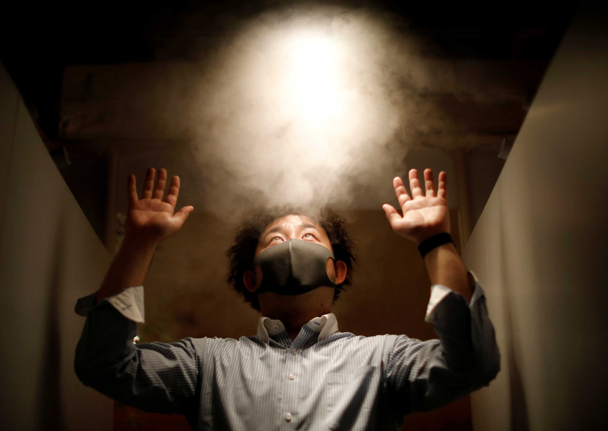 A man is sprayed with hypochlorous acid water as a measure to prevent an infection with the coronavirus disease (COVID-19) at the entrance of Kichiri Shinjuku, a Japanese style pub known as an 'izakaya', in Tokyo, Japan May 19, 2020. REUTERS