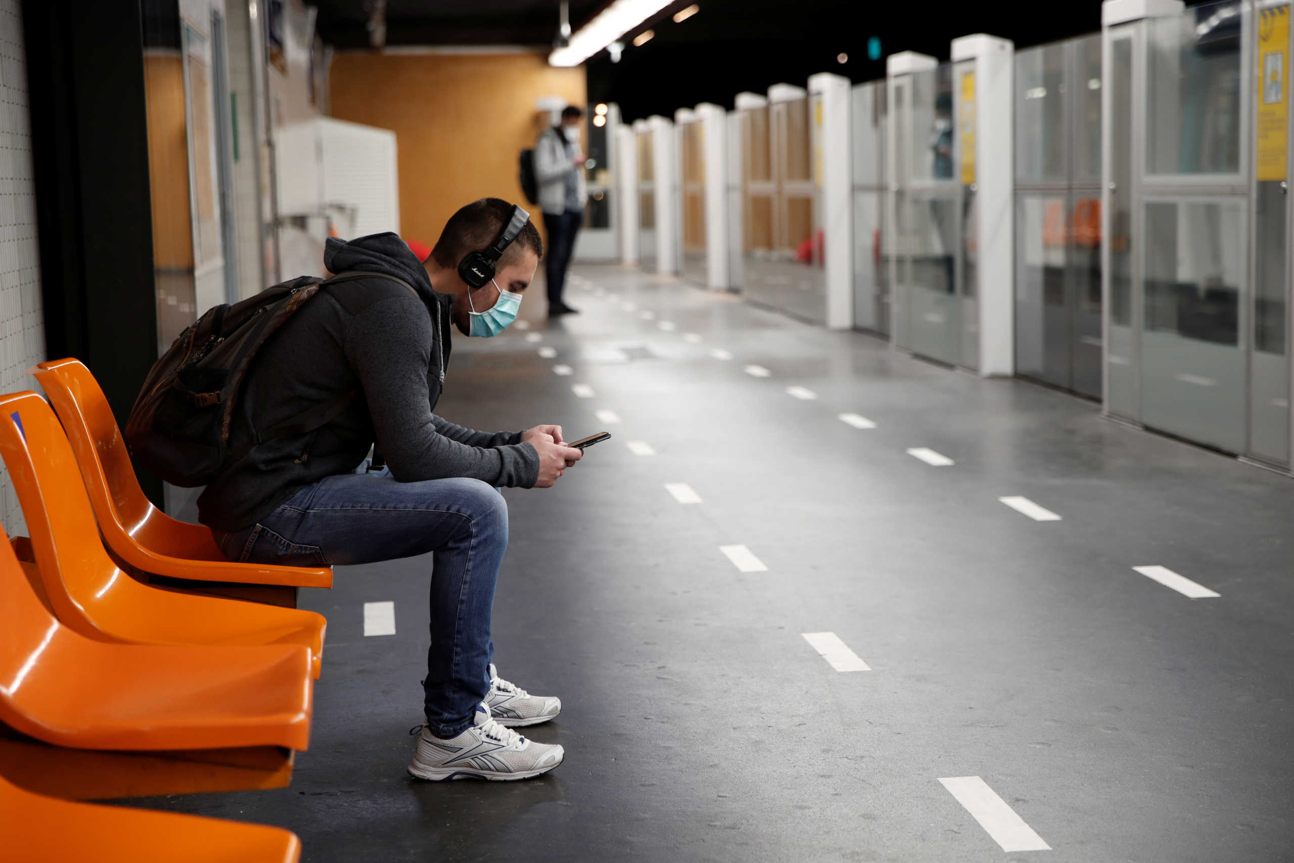 A man wearing a protective face mask sits on a platform at a metro station of Paris transport network (RATP) in Paris as France softens its strict lockdown rules during the outbreak of the coronavirus disease (COVID-19) in France, May 11, 2020.  REUTERS
