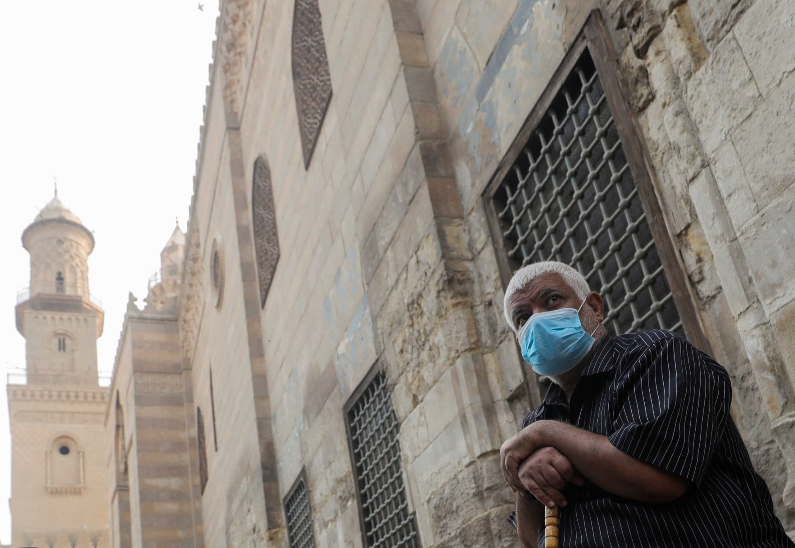 A man wearing a protective face mask, amid concerns over the coronavirus disease (COVID-19), sits before iftar, or breaking fast, during the holy month of Ramadan in front of closed mosques and Islamic schools at El Moez Street in old Islamic Cairo, Egypt April 30, 2020. REUTERS