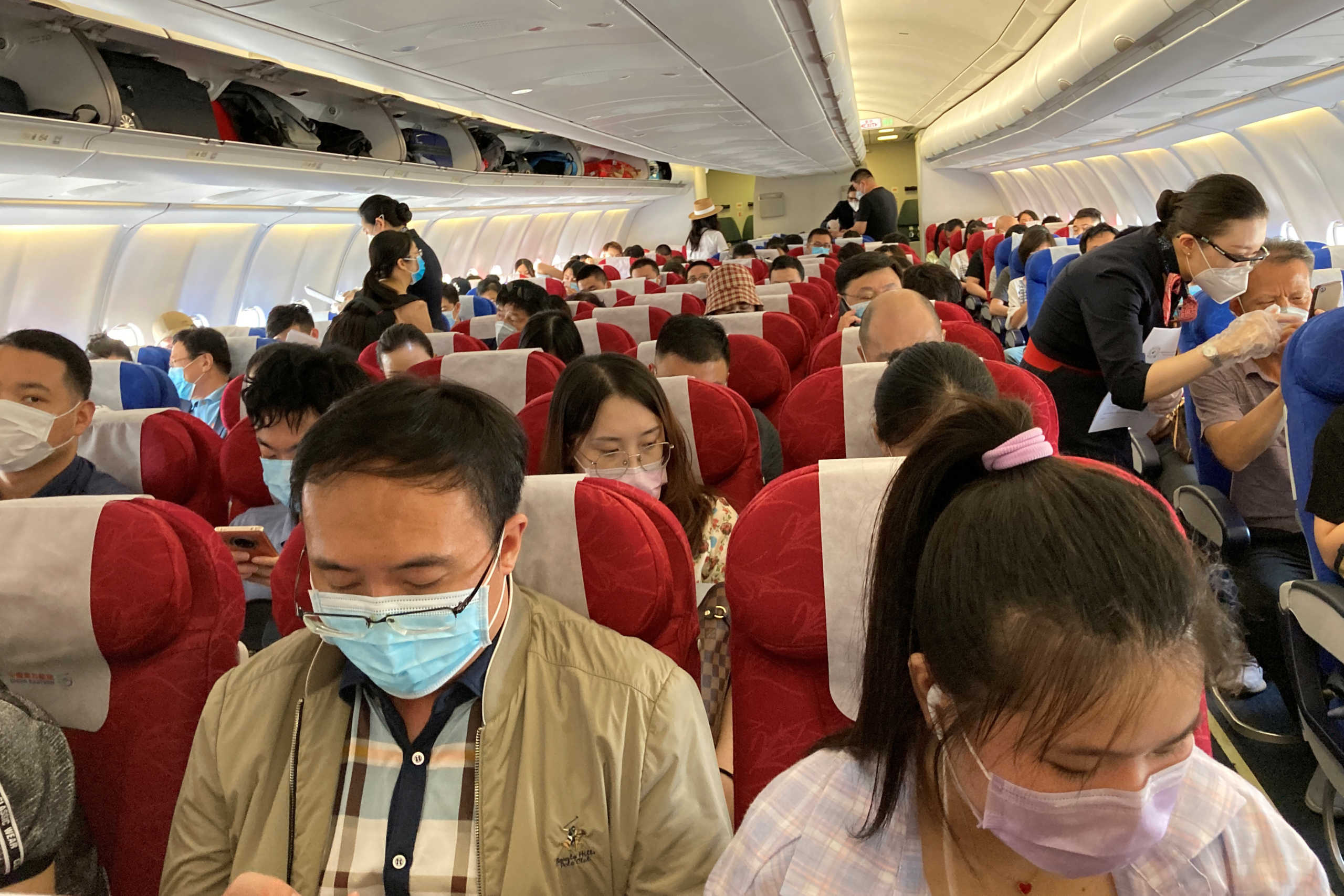 Passengers wearing face masks following the coronavirus disease (COVID-19) outbreak are seen on a China Eastern Airlines flight at Shenzhen Baoan International Airport in Shenzhen, Guangdong province, China May 19, 2020. REUTERS