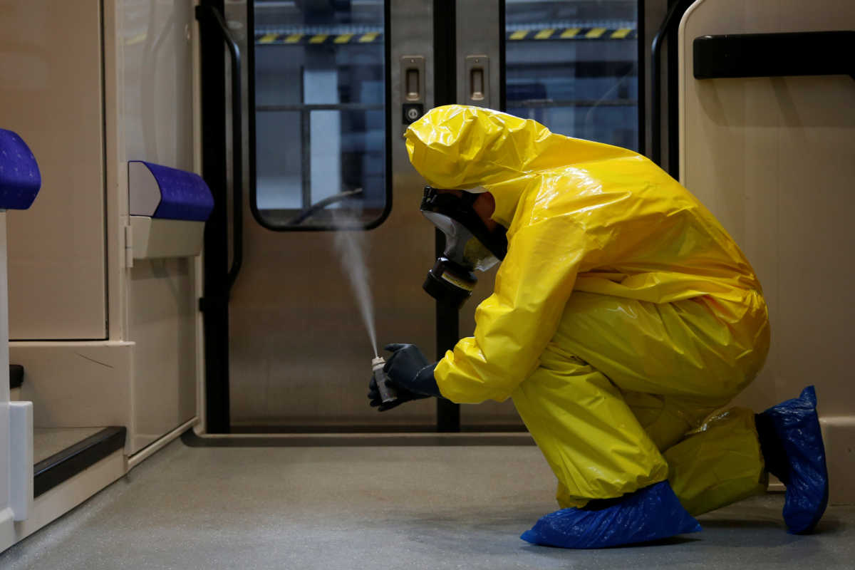 A worker, wearing protective suit and face mask, sprays disinfectant during a decontamination operation inside a TER regional train at the SNCF maintenance workshop in Lille during the outbreak of the coronavirus disease (COVID-19) in France, May 4, 2020. REUTERS