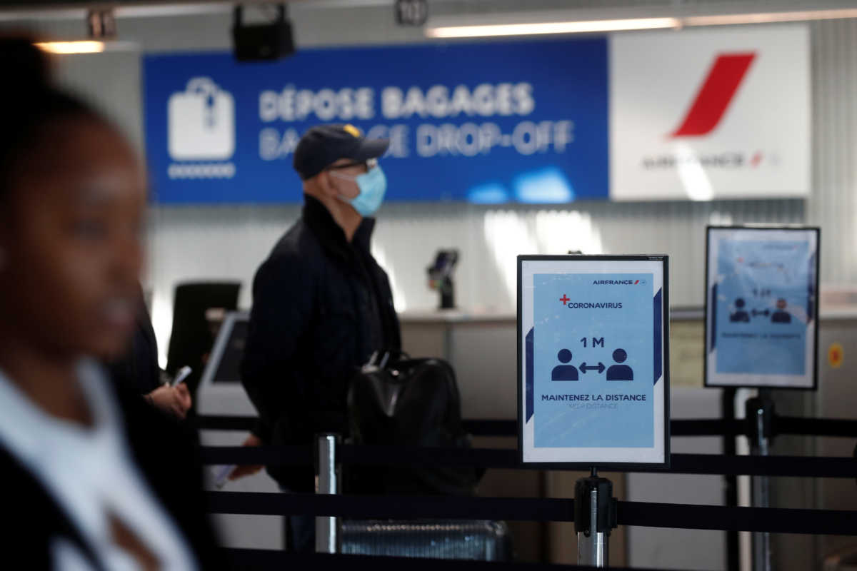 Passengers wearing protective face masks maintain social distance as they queue in Terminal 2E at Paris Charles de Gaulle airport in Roissy-en-France during the outbreak of the coronavirus disease (COVID-19) in France, May 6, 2020. REUTERS