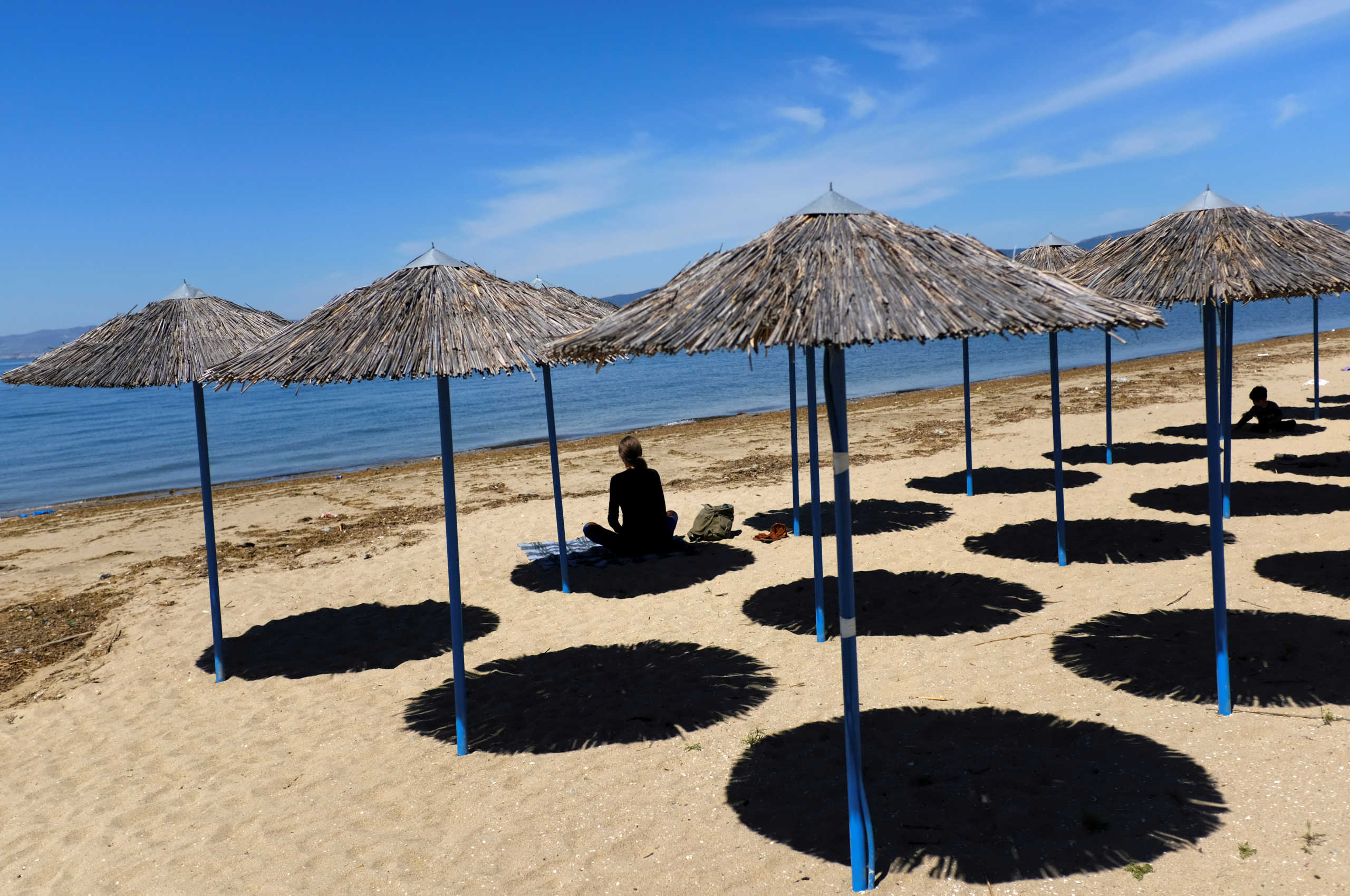 A woman sits at Peraia beach as Greece begins a gradual easing of the nationwide lockdown due to the spread of the coronavirus disease (COVID-19), in Thessaloniki, Greece, May 5, 2020. REUTERS