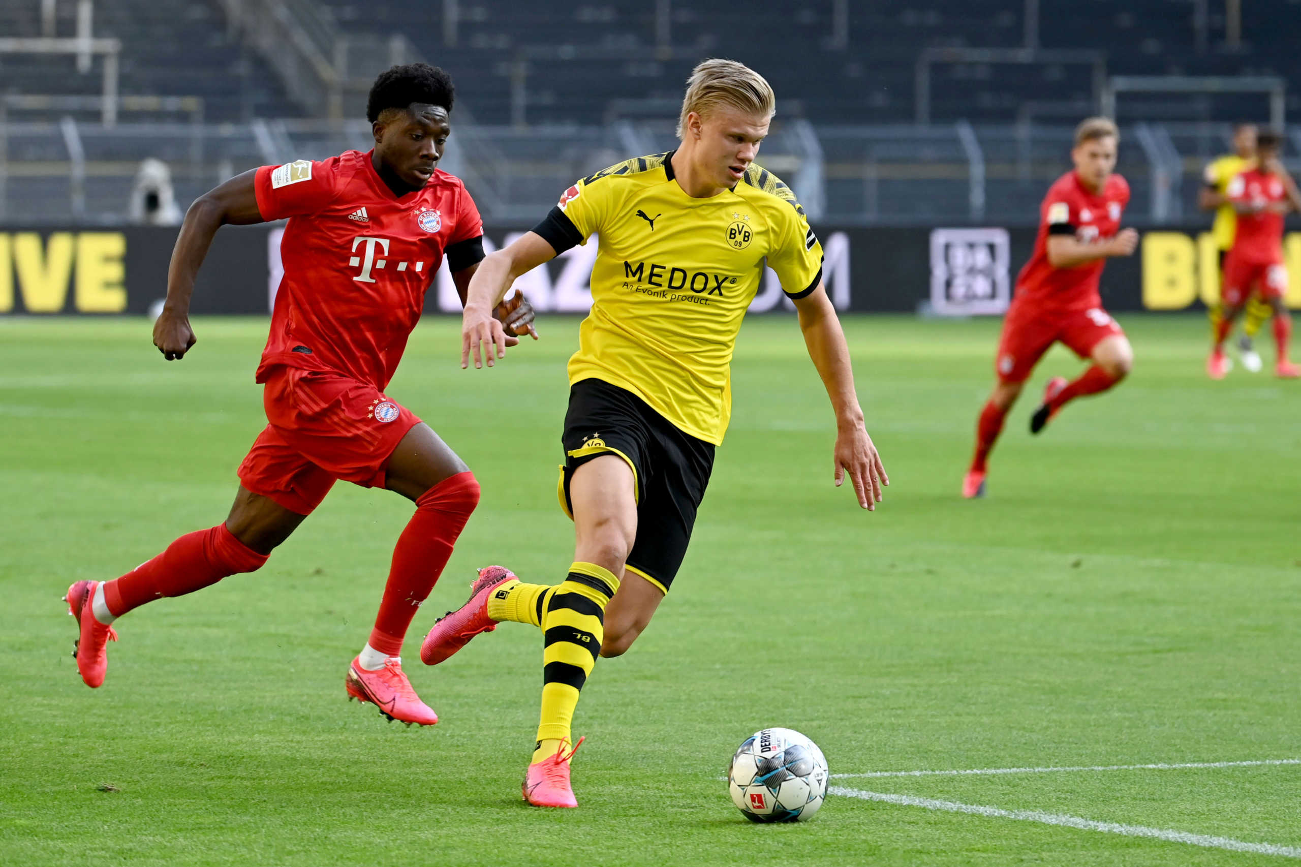 Soccer Football - Bundesliga - Borussia Dortmund v Bayern Munich - Signal Iduna Park, Dortmund, Germany - May 26, 2020 Borussia Dortmund's Erling Braut Haaland in action with Bayern Munich's Alphonso Davies, as play resumes behind closed doors following the outbreak of the coronavirus disease (COVID-19) Federico Gambarini