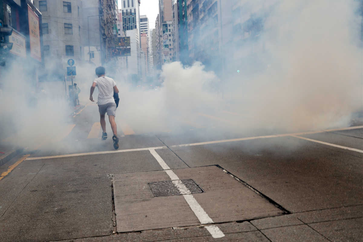An anti-government protester runs away from tear gas during a march against Beijing's plans to impose national security legislation in Hong Kong, China May 24, 2020. REUTERS